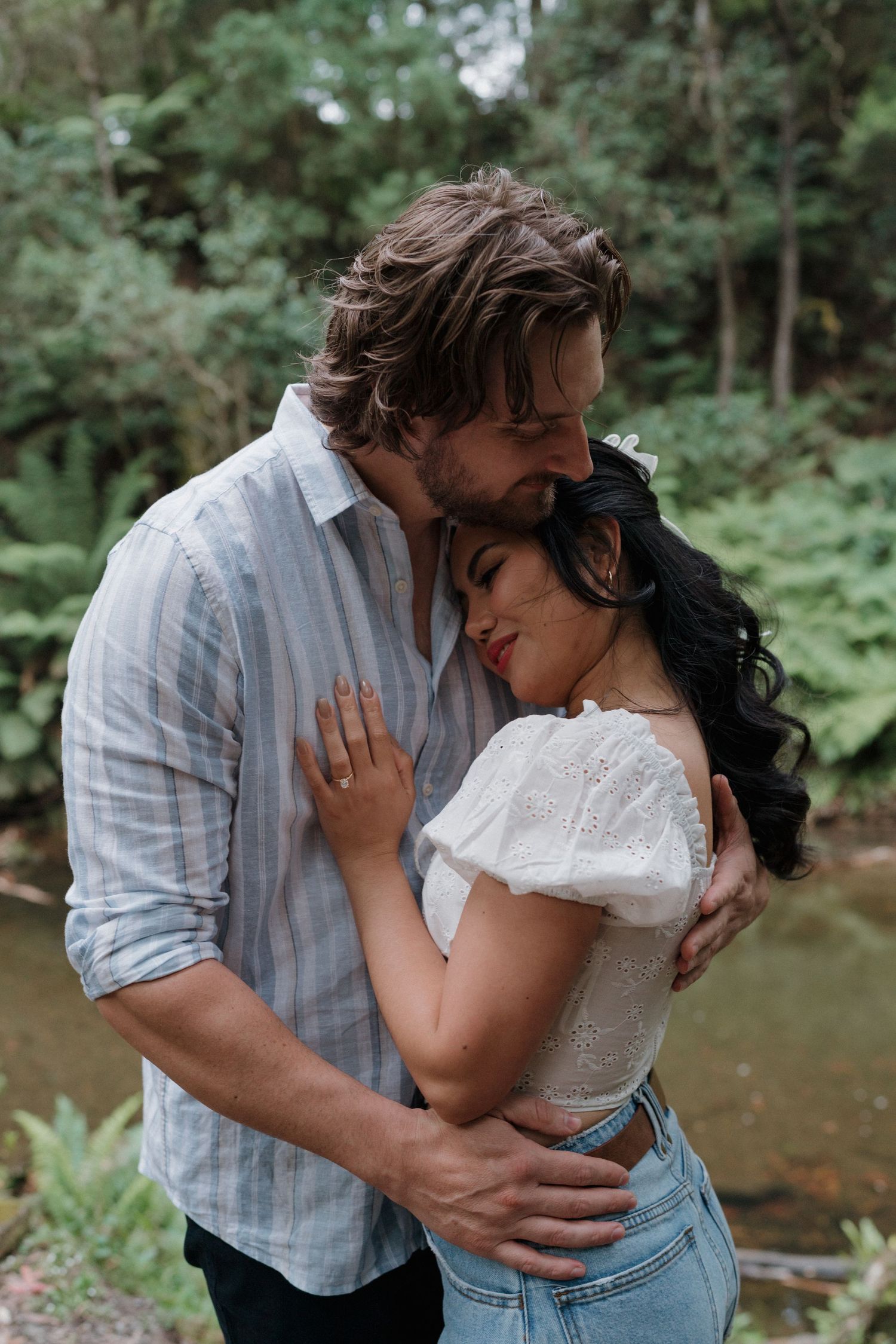 Intimate couple portrait session by a serene forest stream.