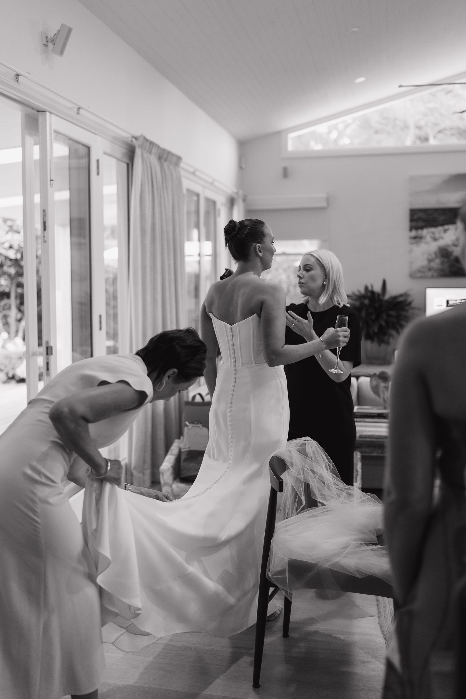 Black and white photo of a bride twirling in her dress during wedding preparations.