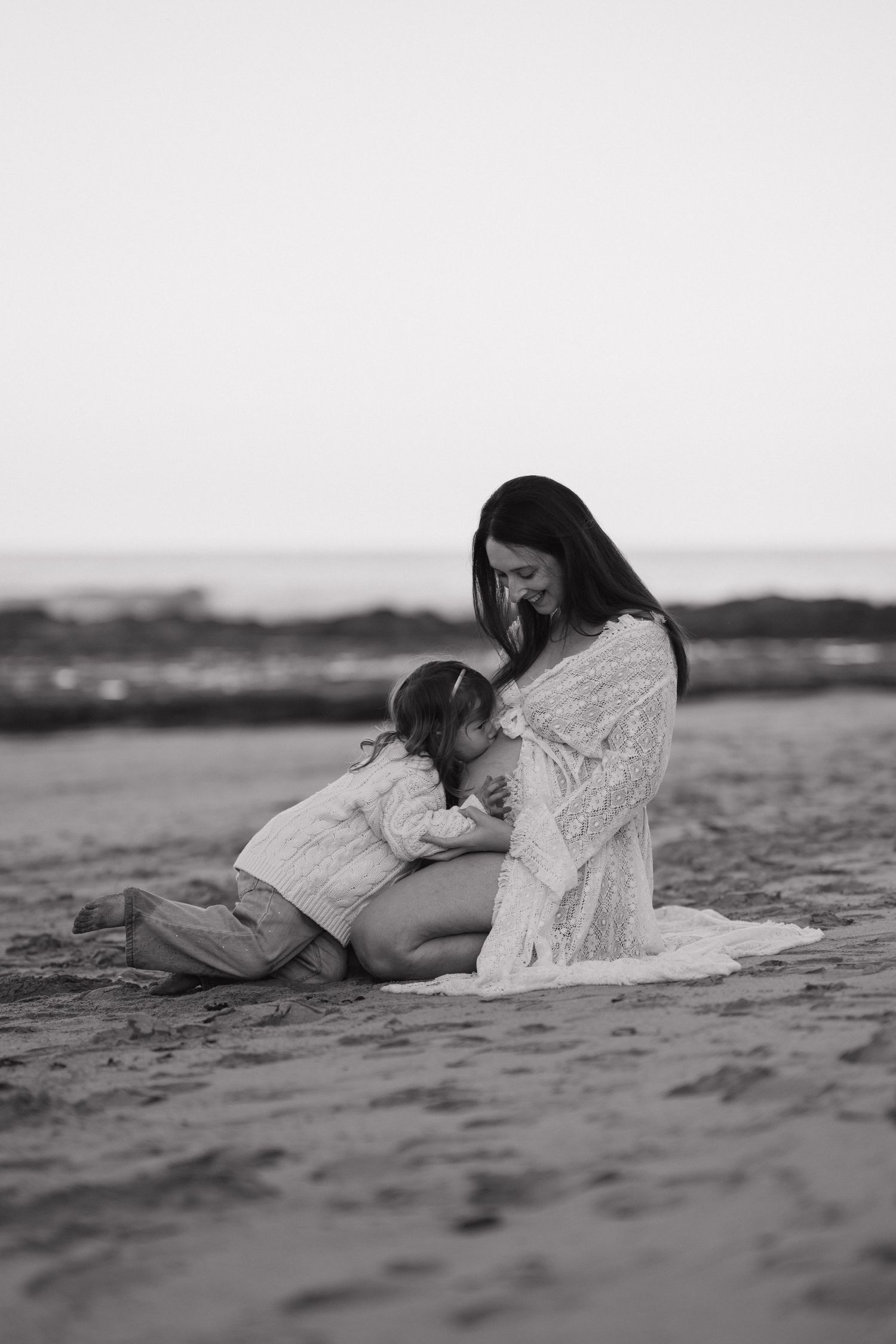 Artistic black and white maternity photos taken on a serene beach in Wye River.