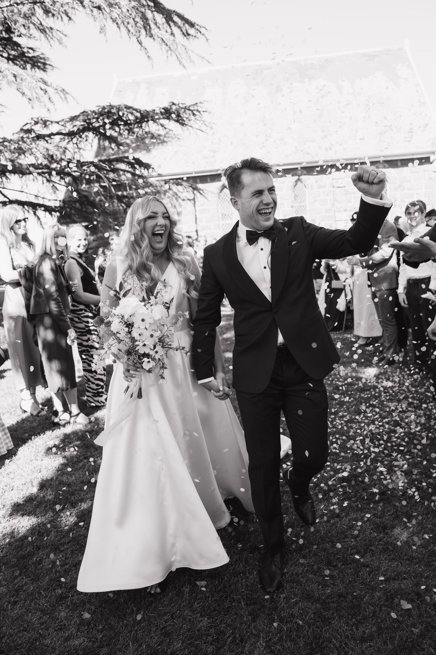 Wedding celebration with confetti toss in black and white.