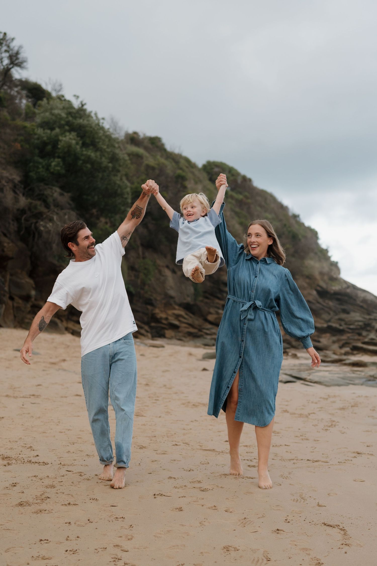 Family playing and dancing together on a cloudy beach in Wye River