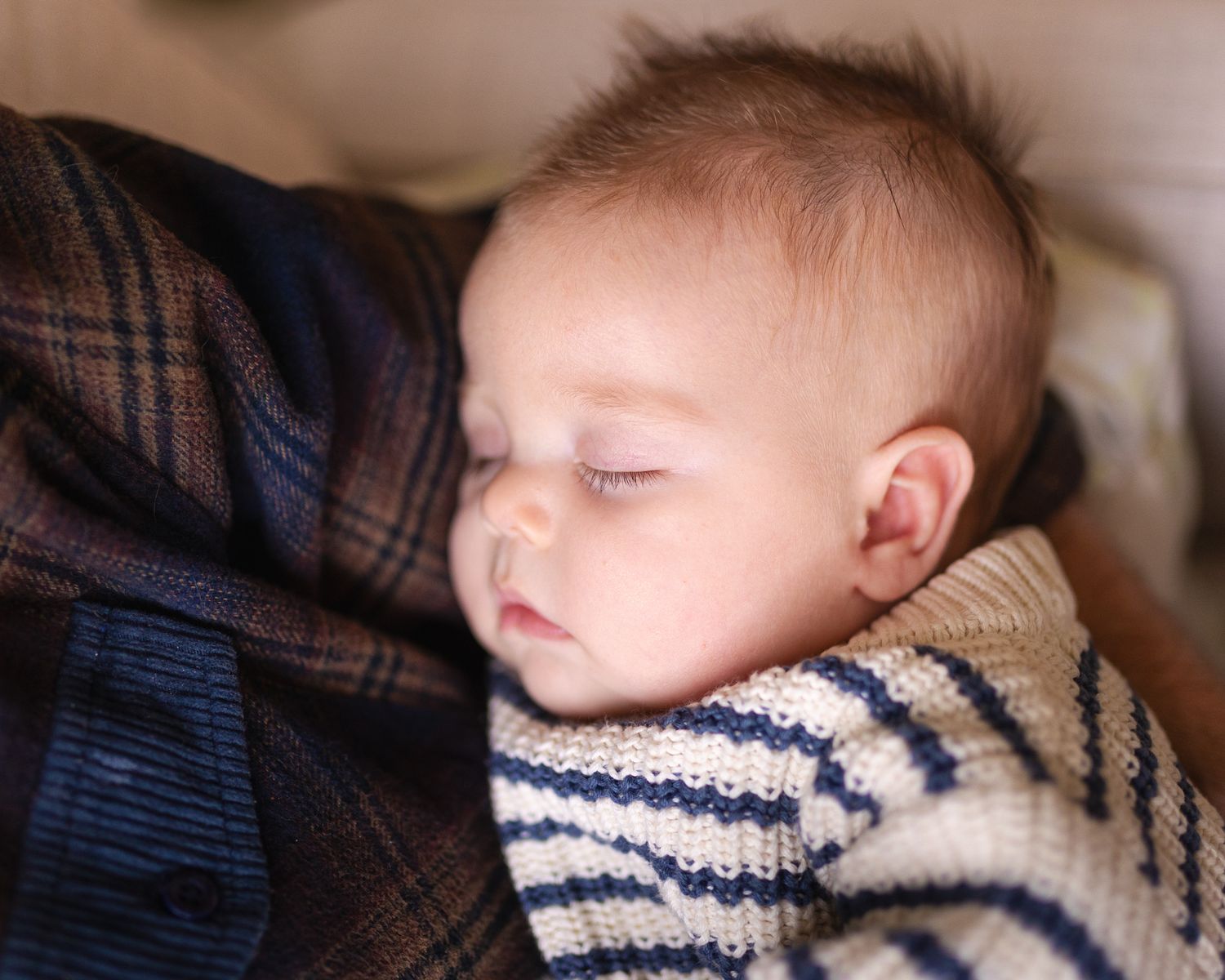 Close-up of young baby in soft fabric under natural lighting.