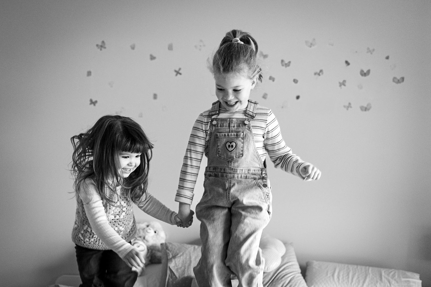 Black and white joyful indoor scene with soft lighting and wallpaper visible.