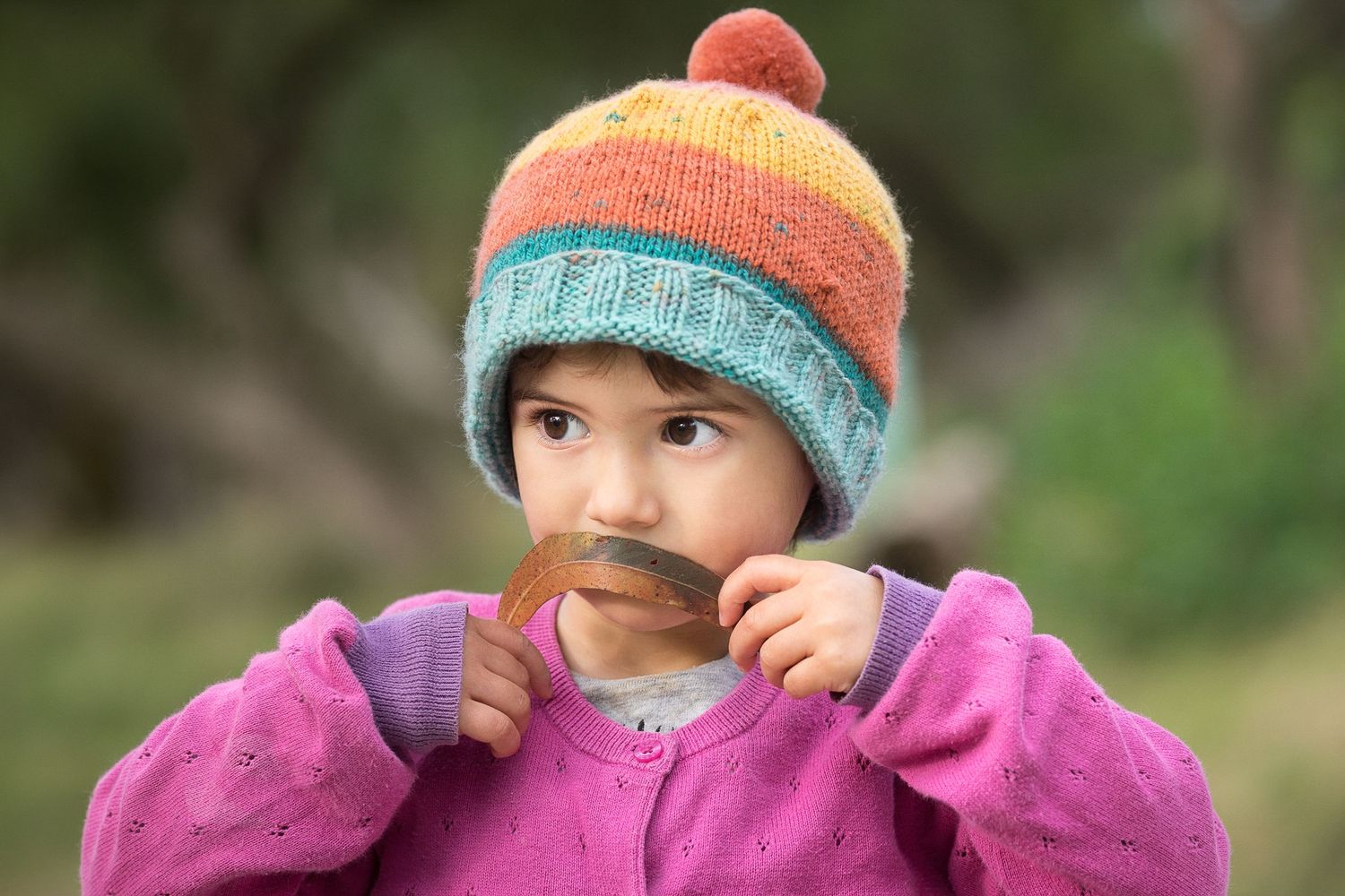 A tender moment with a young person wearing a colourful beanie and pink jacket.