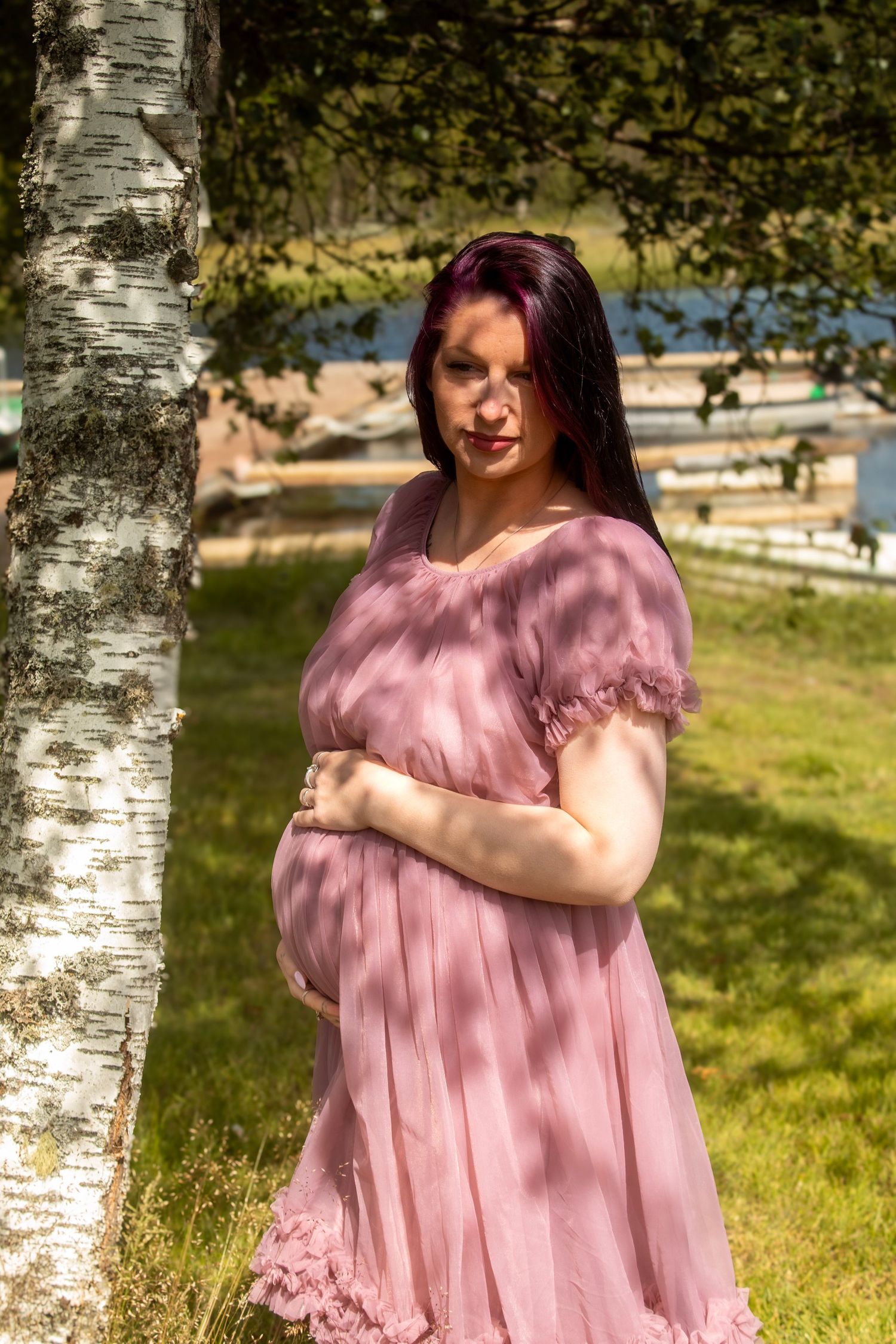 Gravid kvinne i rosa kjole fotografert ved et bjørketre utendørs på Næroset.