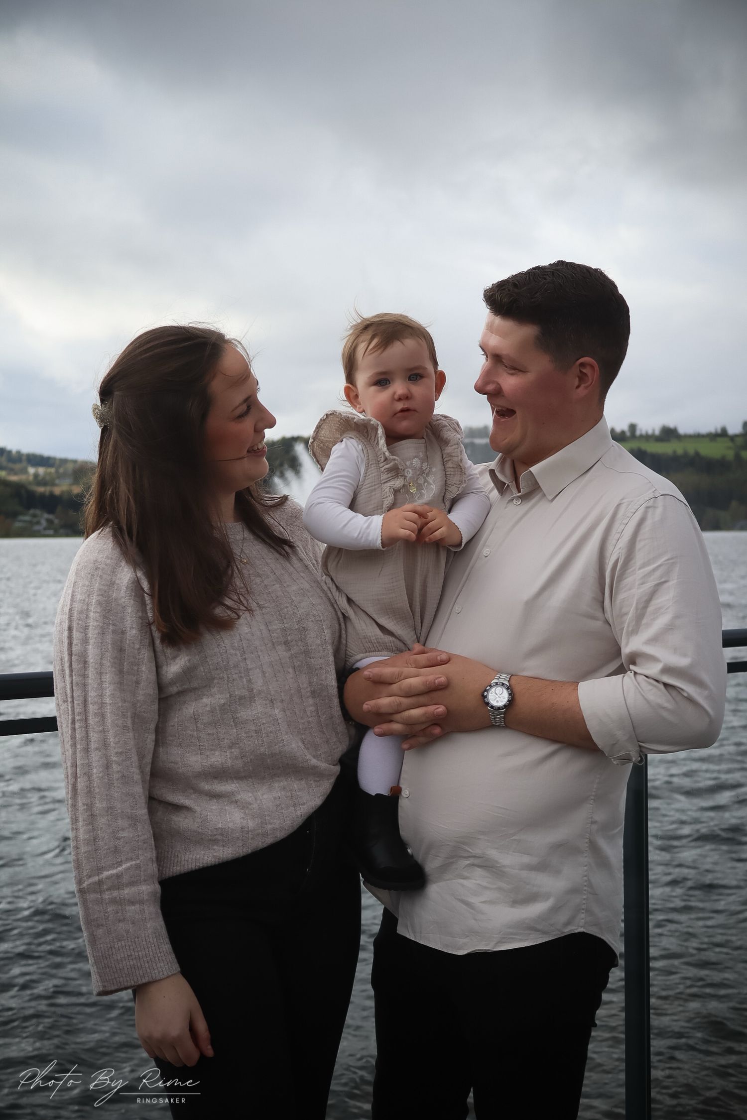 Par fotografert sammen med babyen sin på en brygge ved Mjøsa.