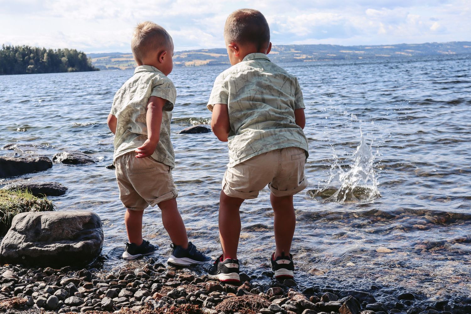 To små gutter i matchende antrekk fotografert sammen ved vannkanten på Helgøya.