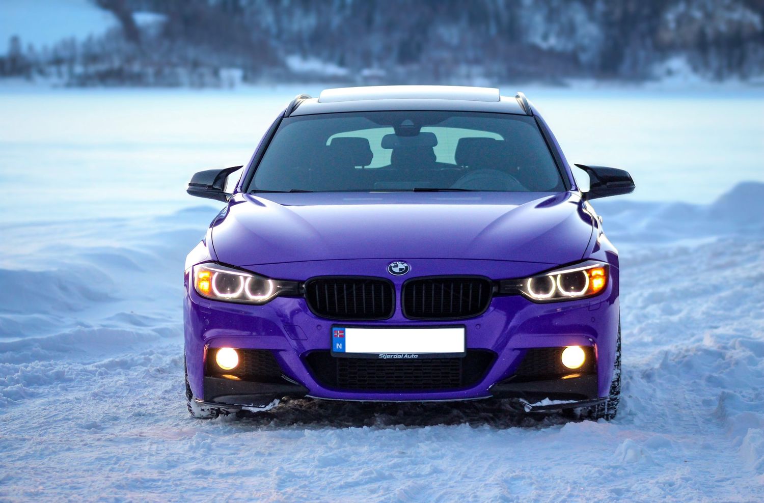 Lilla BMW fotografert i et snødekt vinterlandskap.
