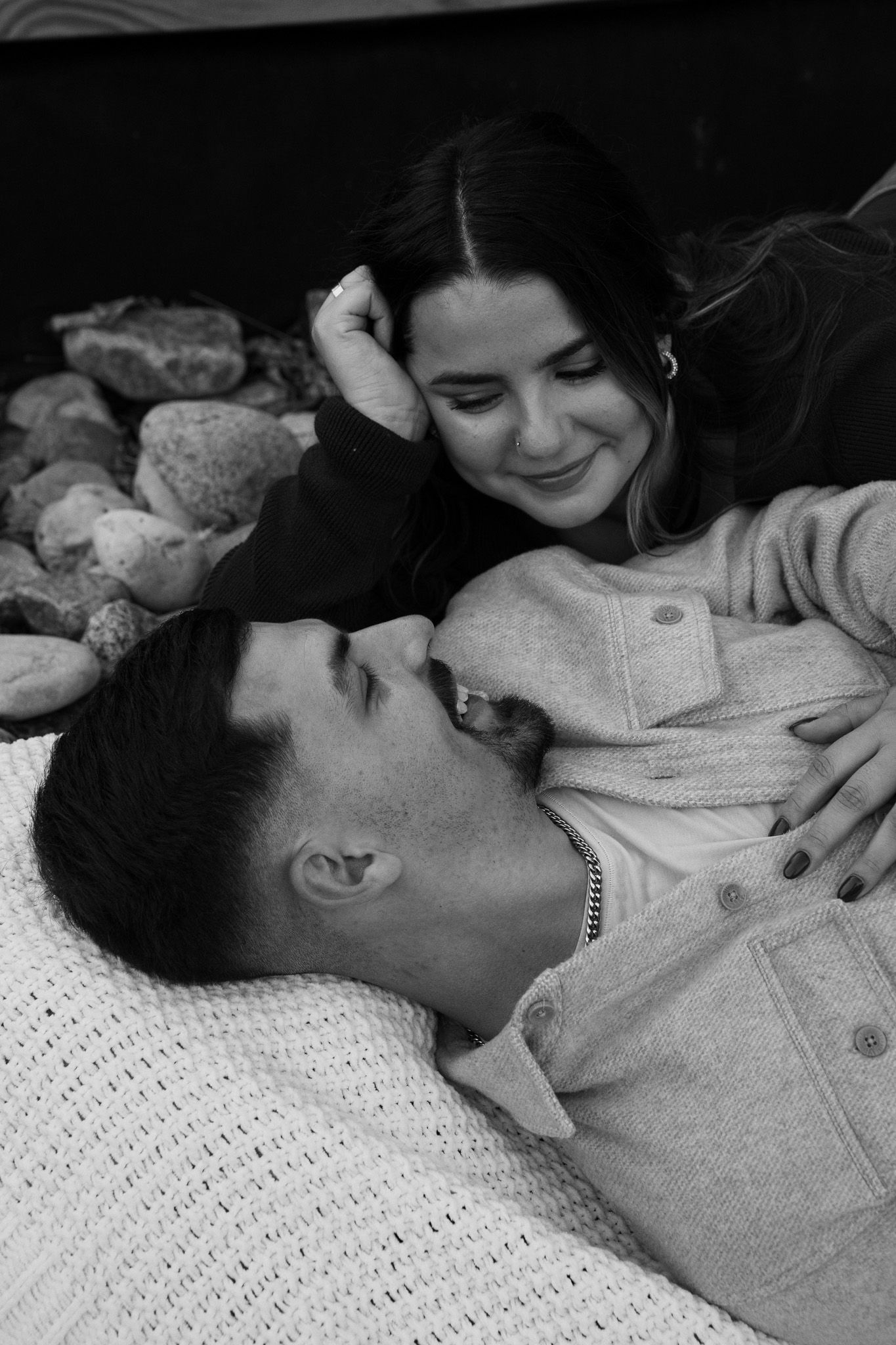 Intimate black and white photos of tender moments on a white knit blanket.