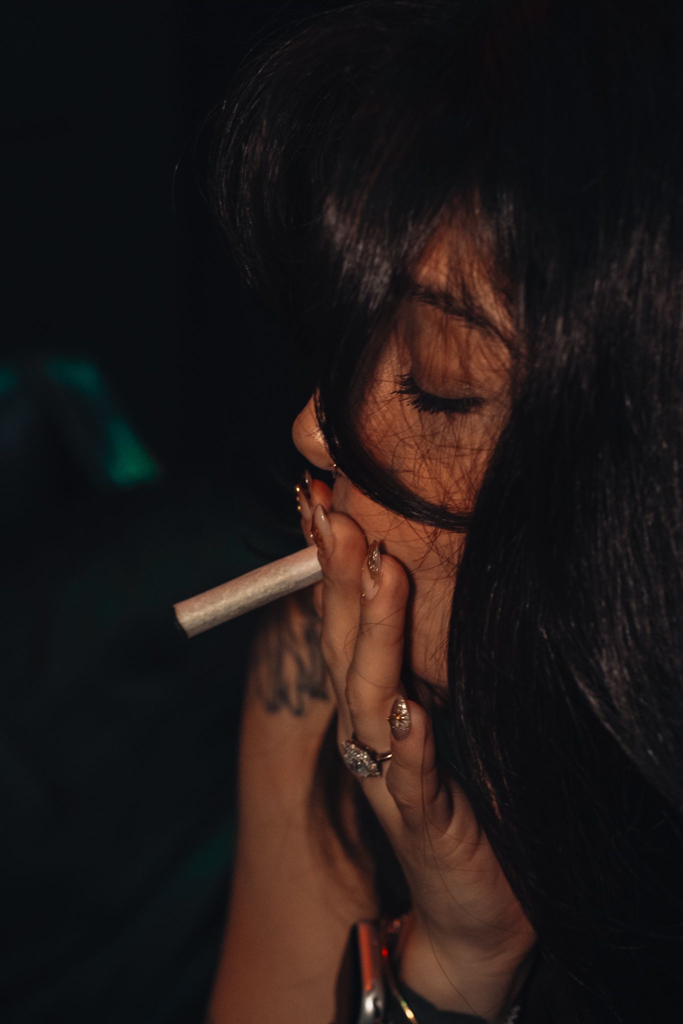A dark and moody portrait series showing someone smoking a cigarette in dramatic shadows with glowing highlights.