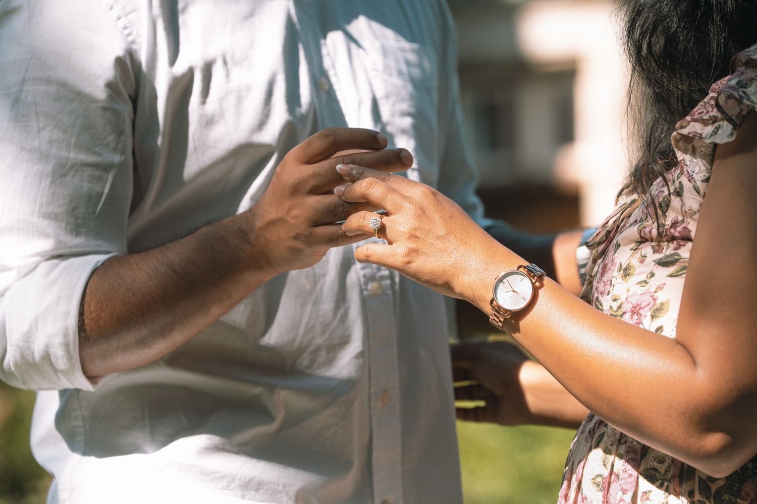 A romantic outdoor photoshoot shows a couple in white and floral clothing.