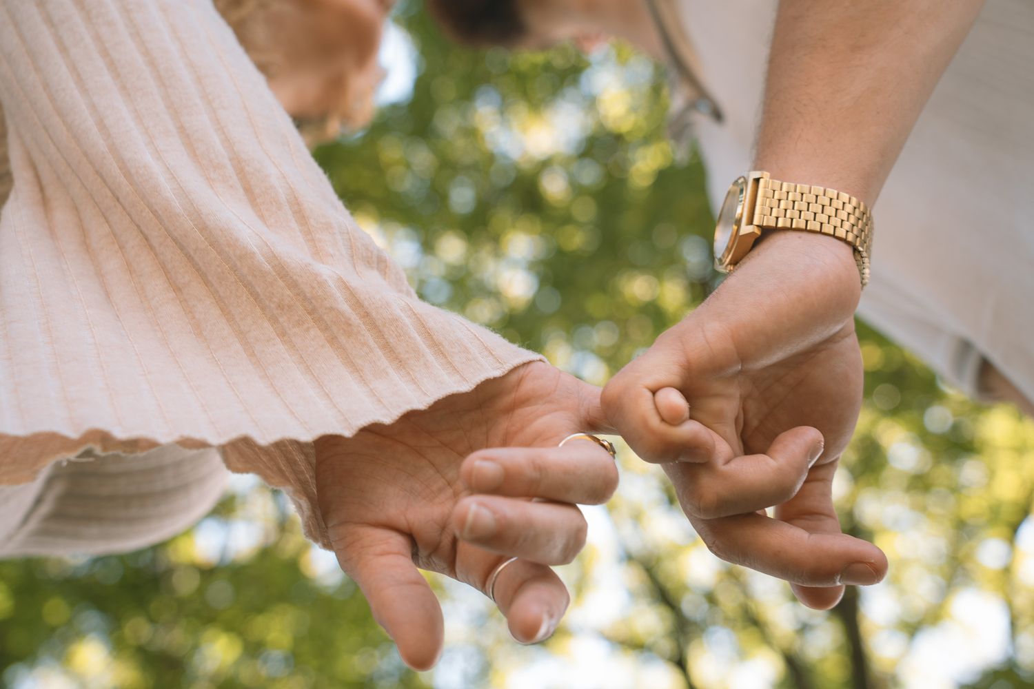 Close-up shots of hands holding and interacting in natural outdoor lighting.
