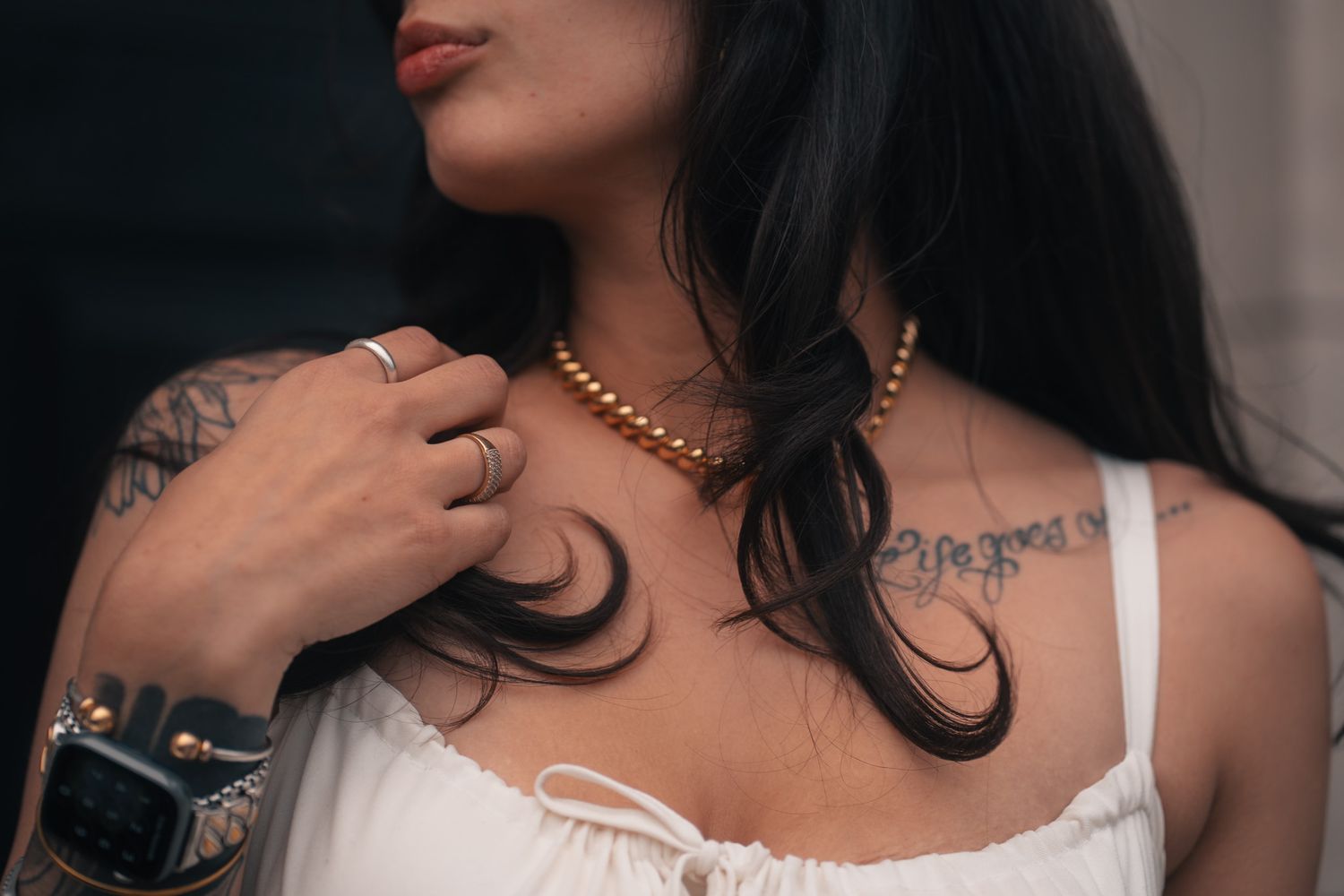 A series of close-up shots showing dark hair, white clothing, and gold jewelry details against a neutral background.