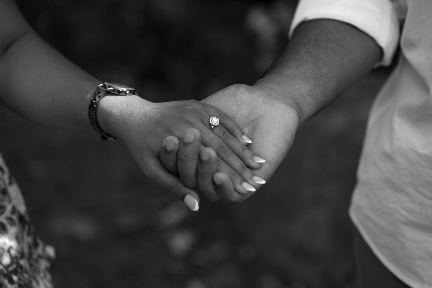 Close-up details of hands and rings during an engagement photoshoot.