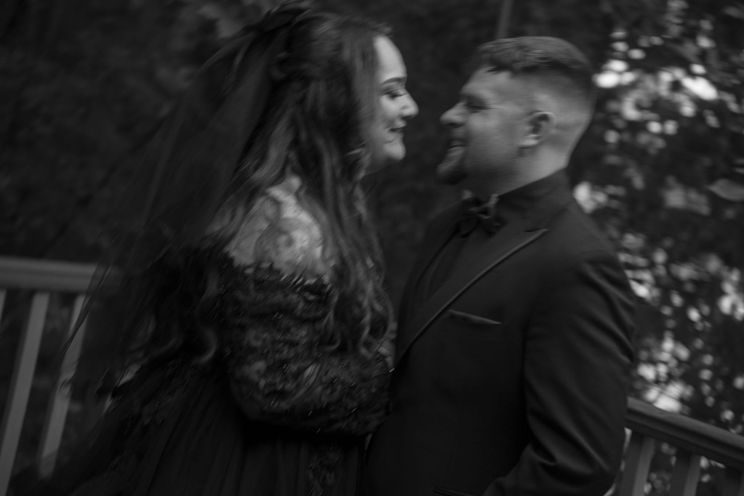Intimate black and white portrait of couple sharing tender moment outdoors.