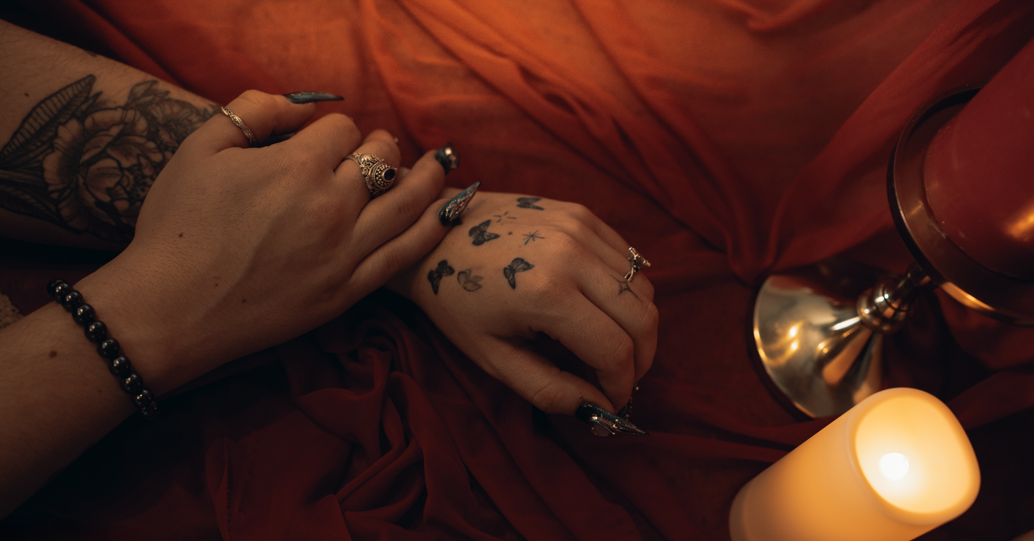 Hands holding and lighting candles in a dimly lit room creating a warm, intimate atmosphere.