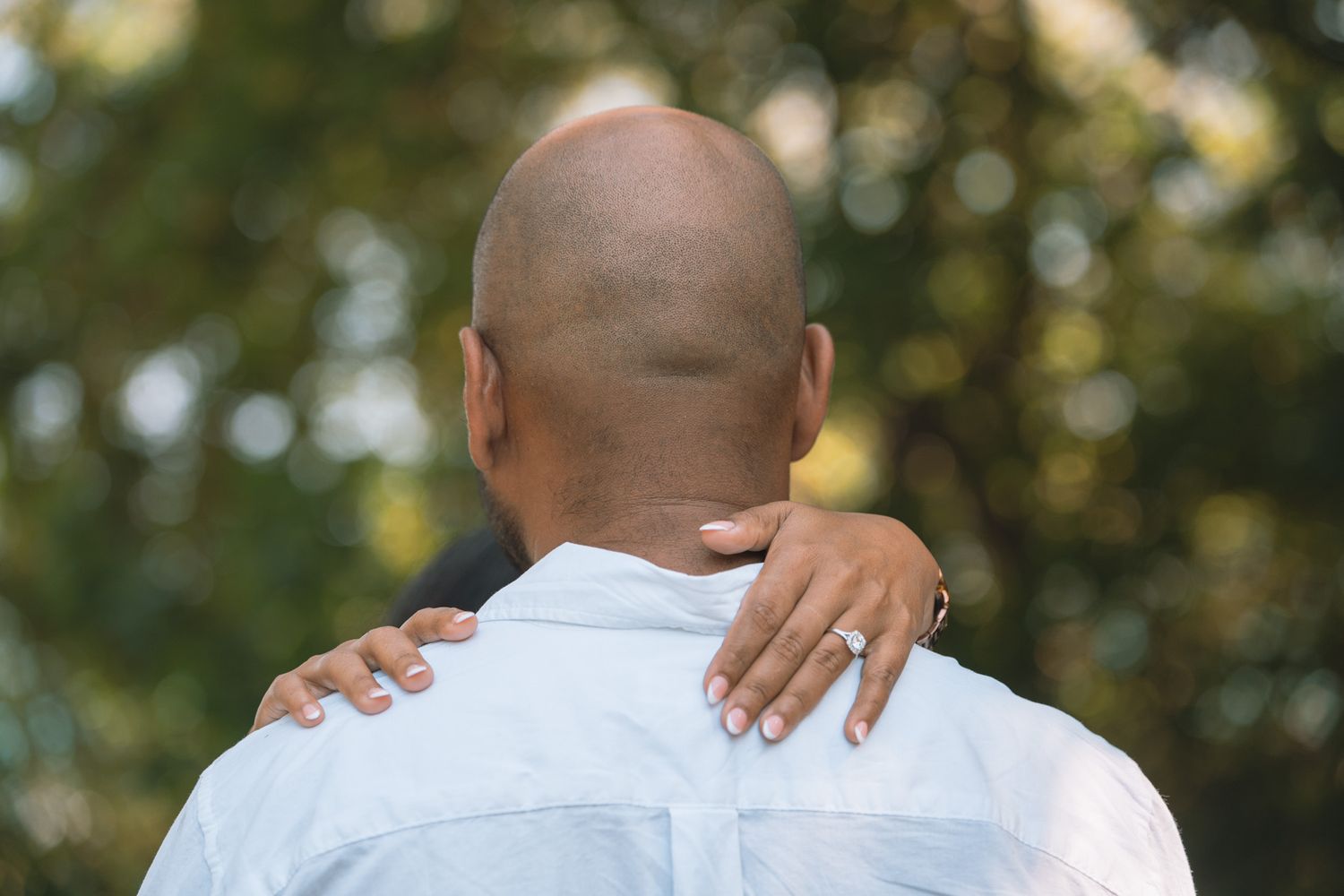 A couple embraces tenderly outdoors in a romantic photoshoot series.