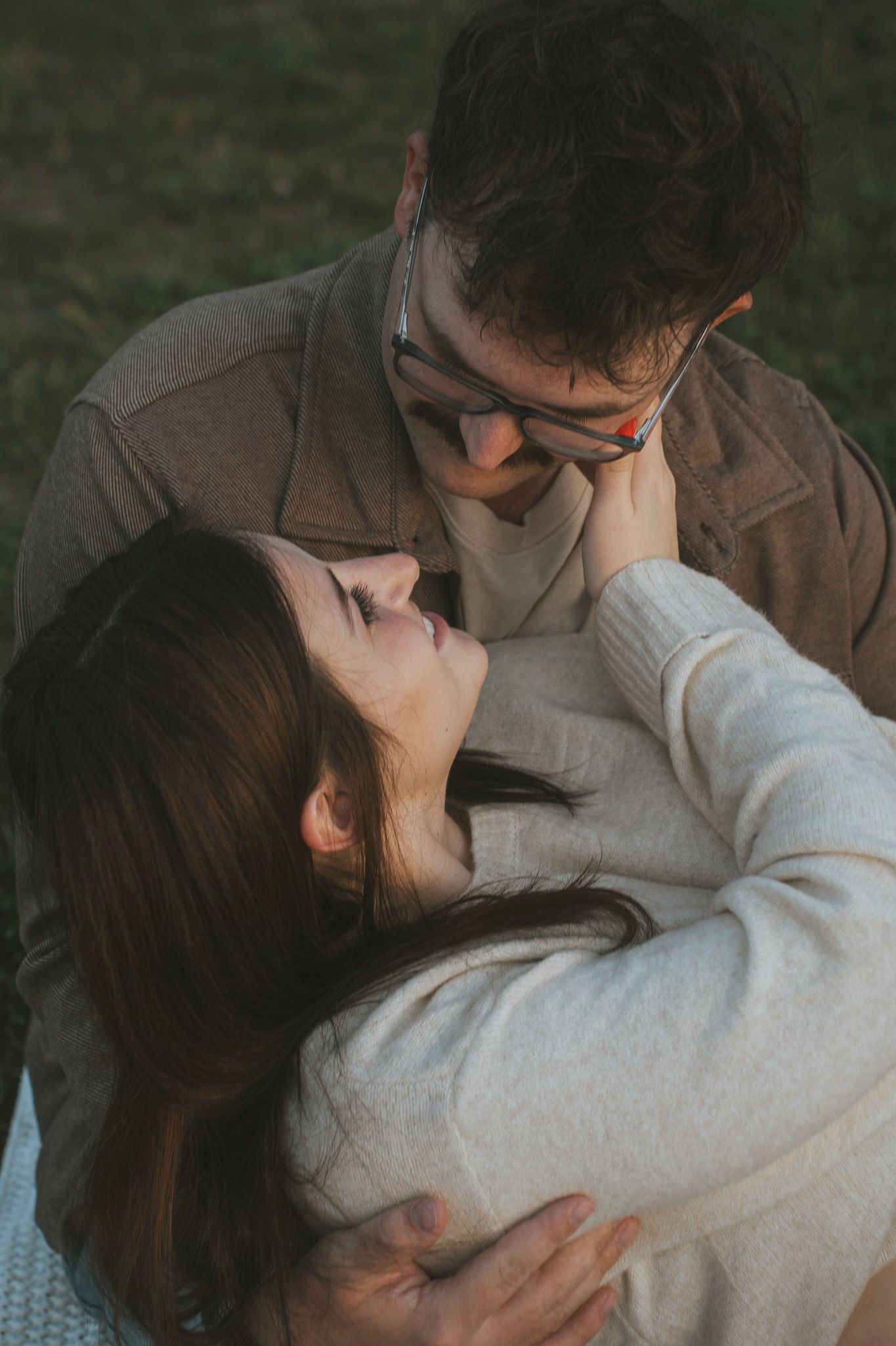 Intimate moment between two people sharing an embrace outdoors at sunset.