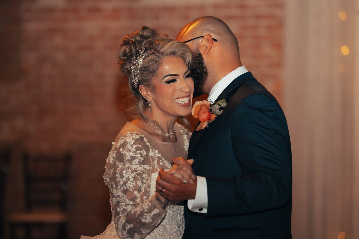 Romantic moment captured during wedding first dance with soft lighting.