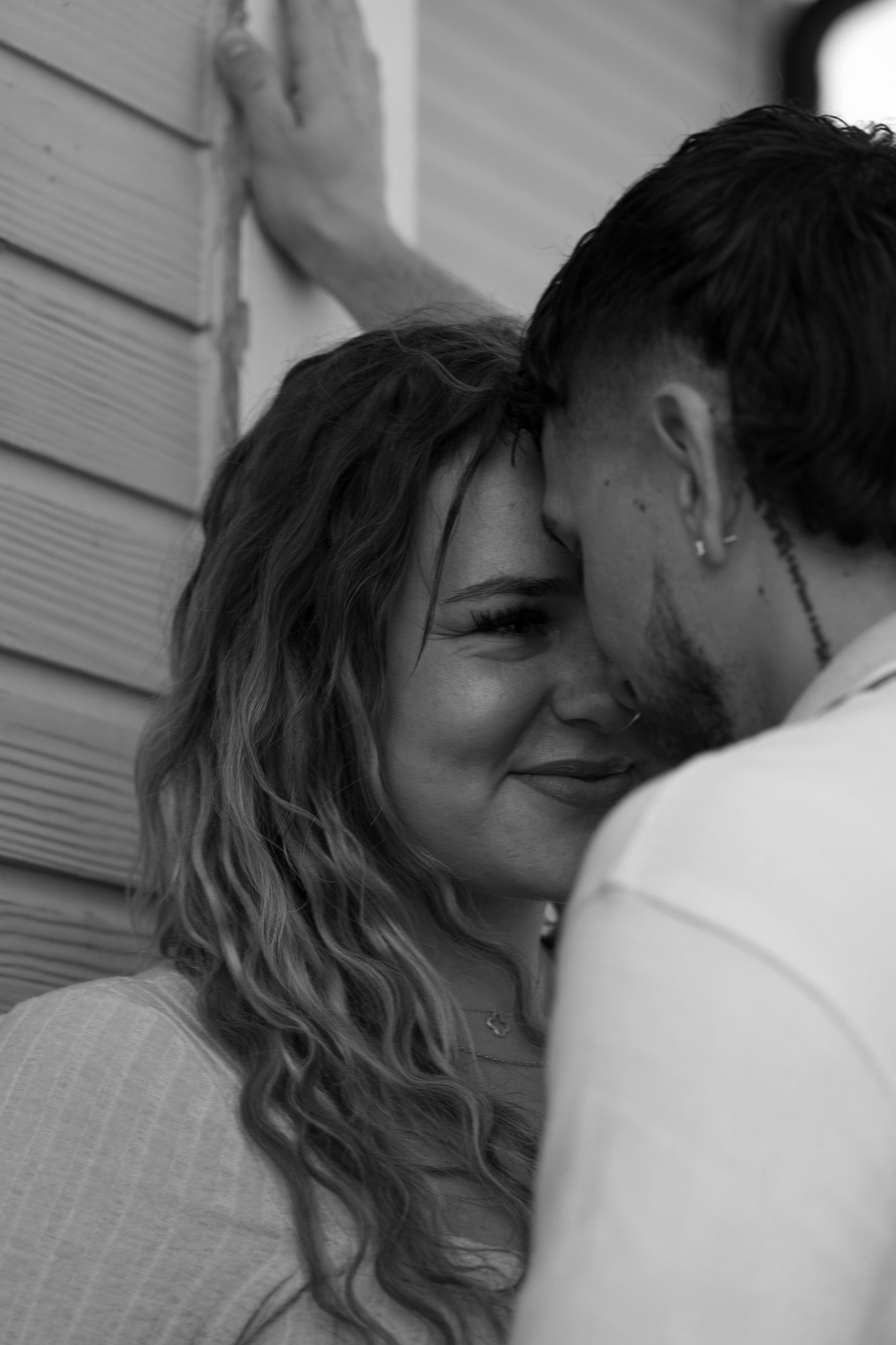 A series of intimate black and white close-up shots showing affection between two people.