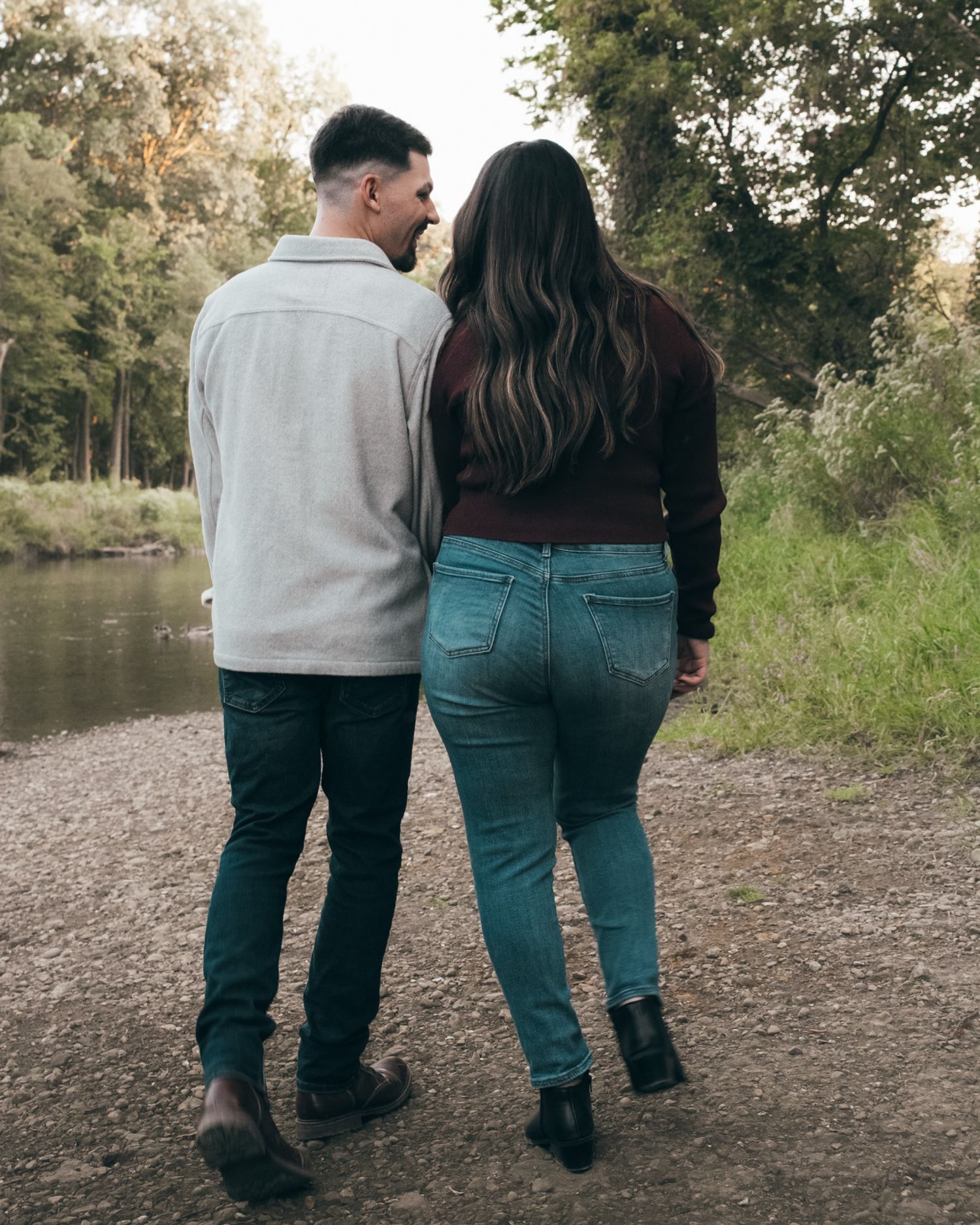 Couple walking together along a peaceful riverside path.