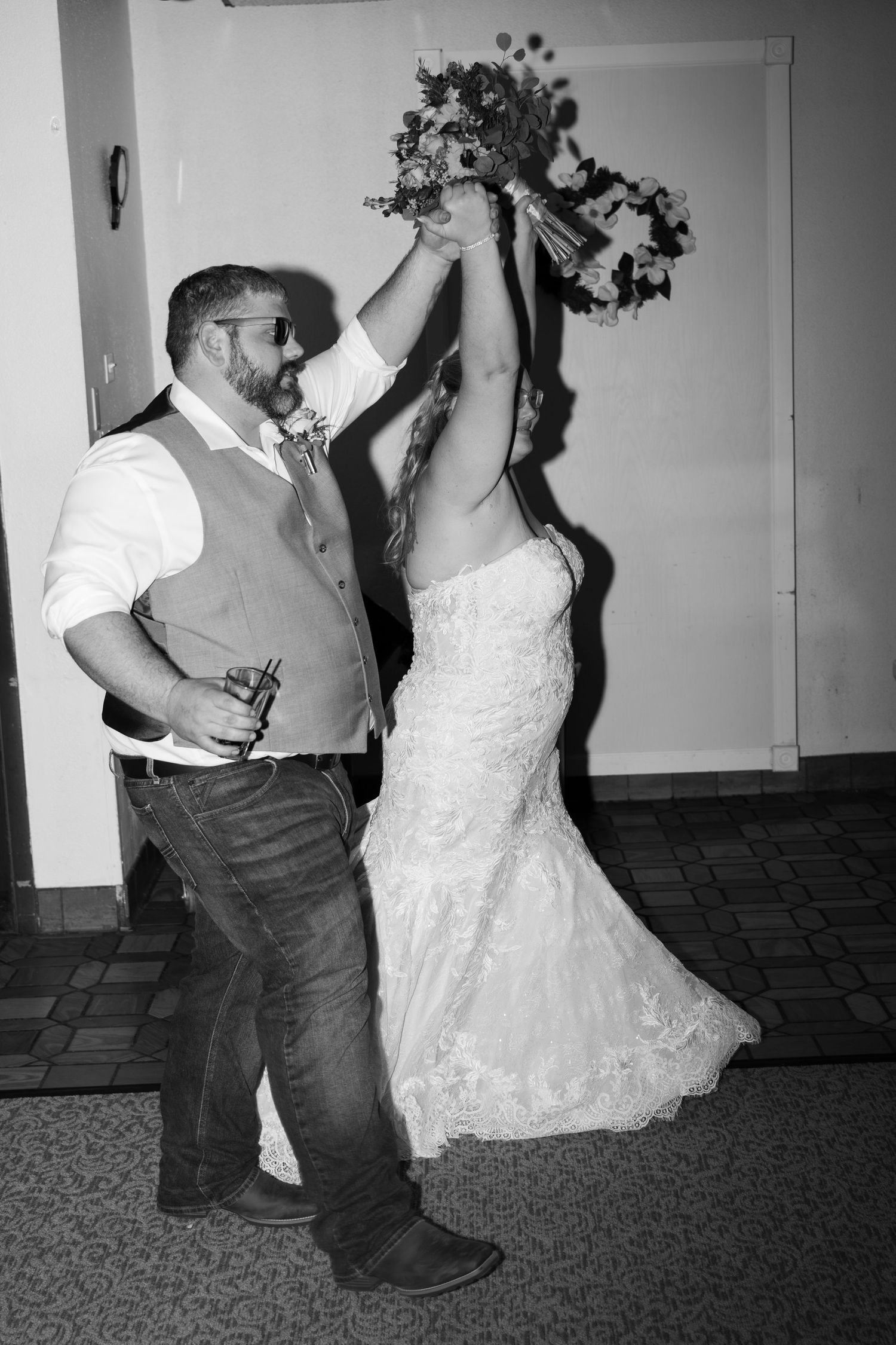 A wedding celebration moment captured in black and white with a dancing couple.