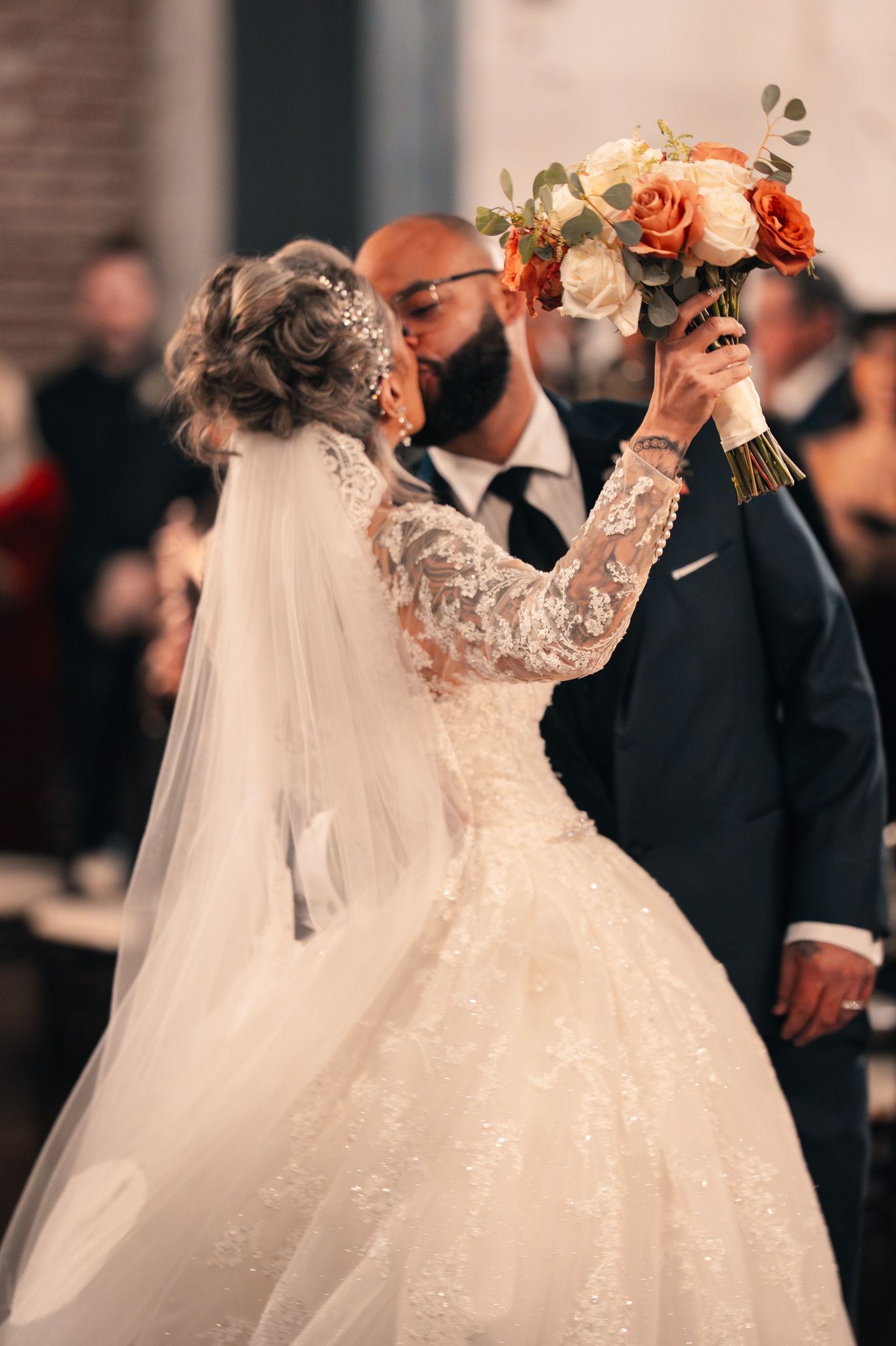 Wedding celebration with flowing white dress and floral details in soft focus.