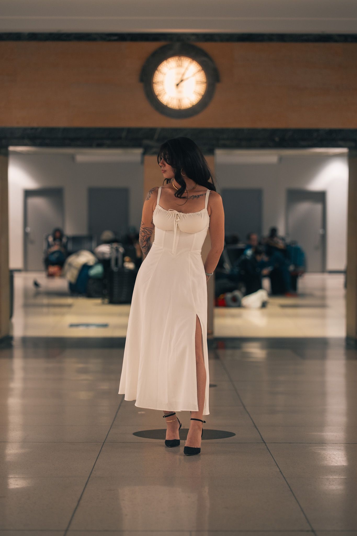 A person in a flowing white dress walks across a polished floor in a series of sequential motion shots.