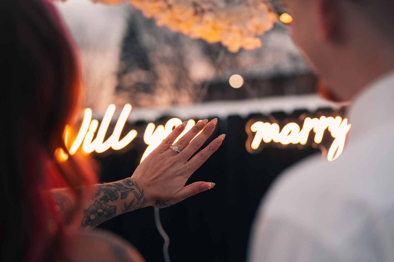 Blurred neon lights and bokeh effects create an atmospheric nighttime scene with warm glowing orbs in the background.