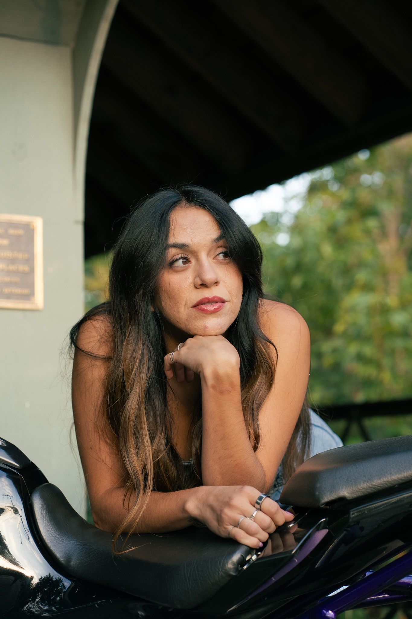 Artistic motorcycle portrait with natural lighting under bridge.