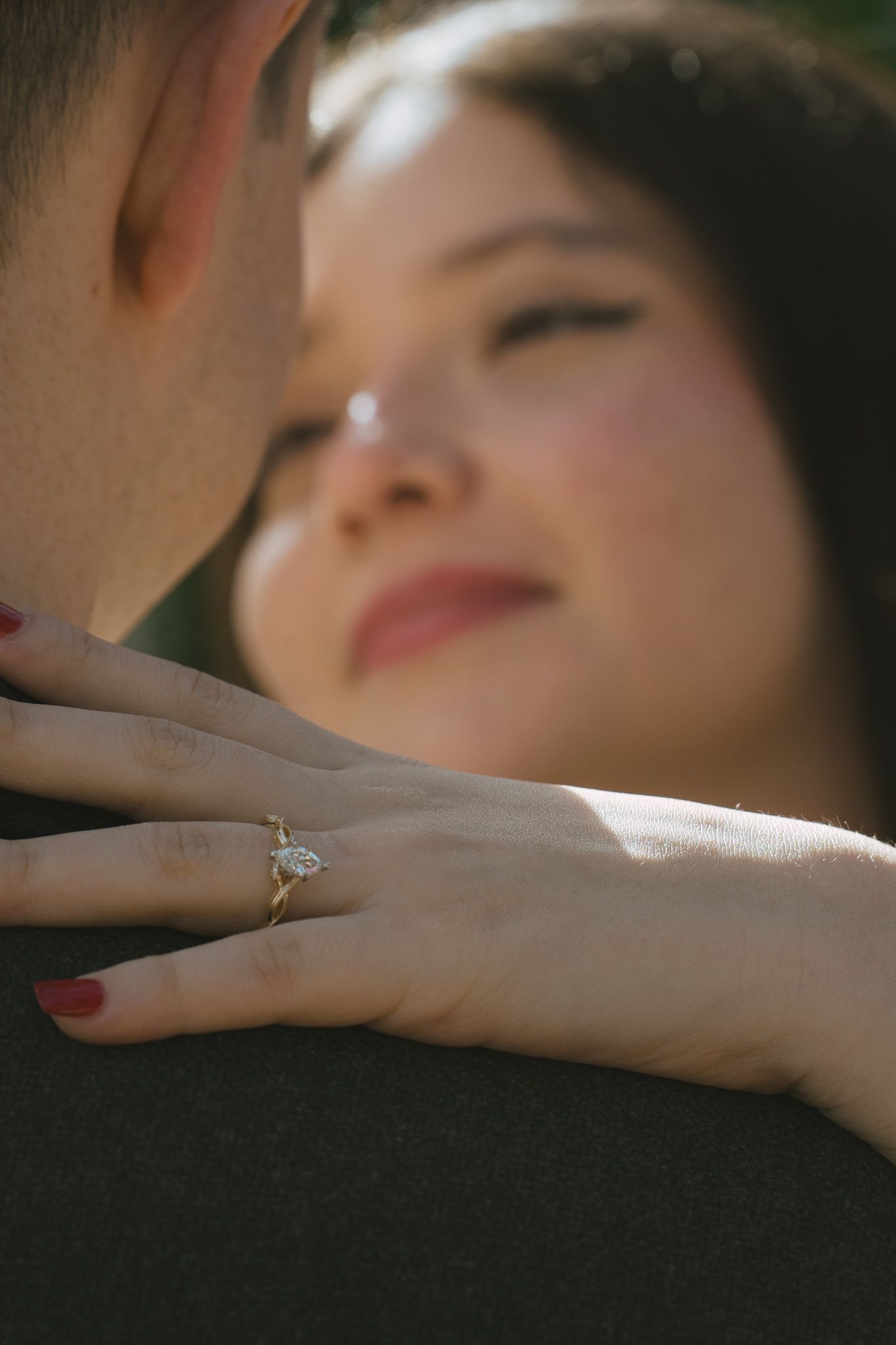 Close-up series showing an engagement ring being placed on a woman's finger in soft natural lighting.