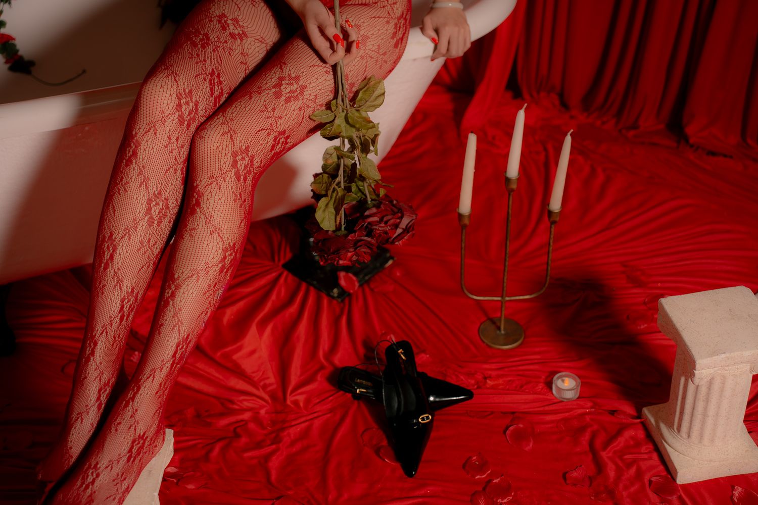 Red Christmas decorations and lights create a festive holiday display with white fishnet stockings and greenery.