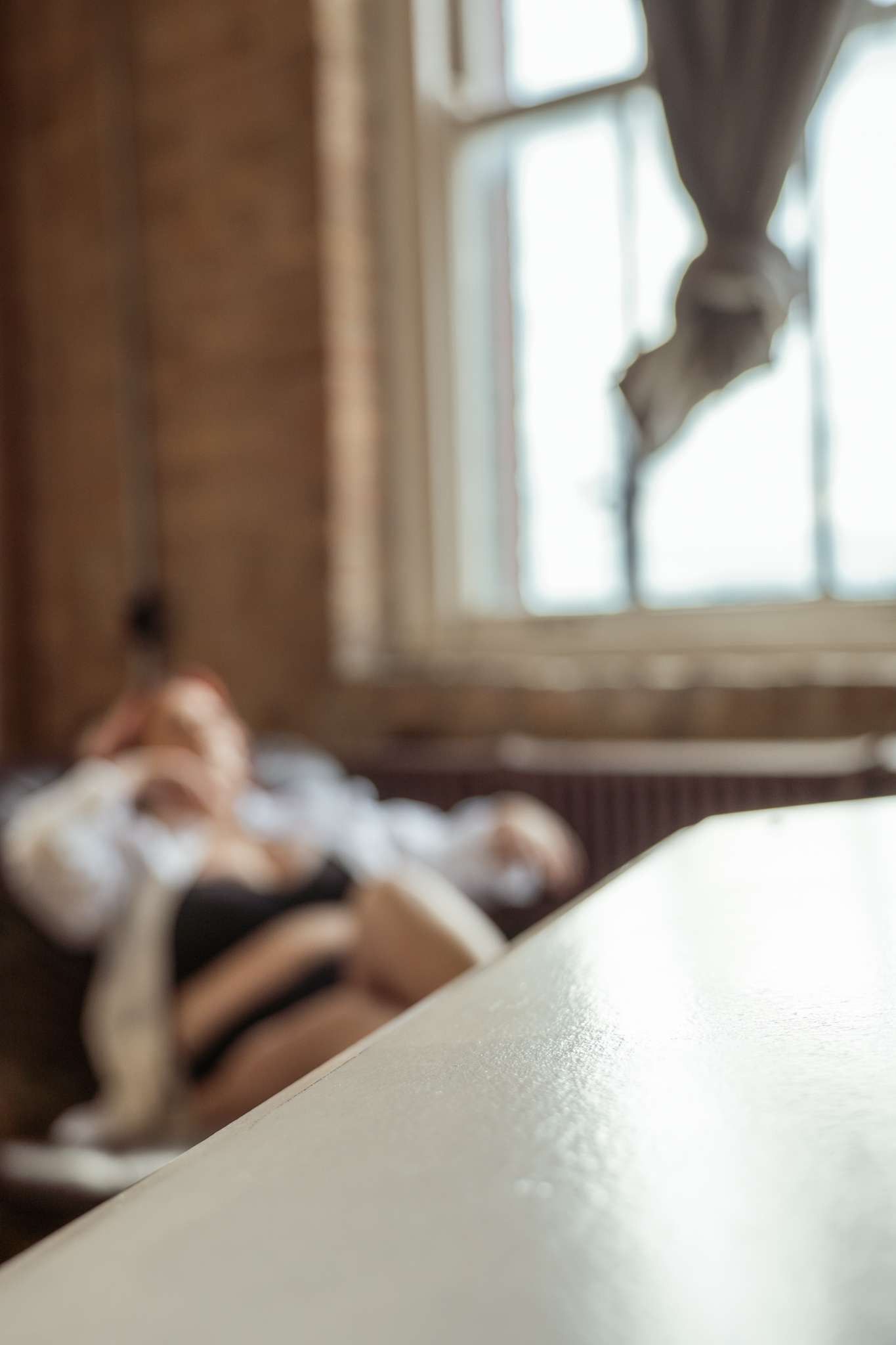 Soft focus image of white bedding in morning light with brick wall background.