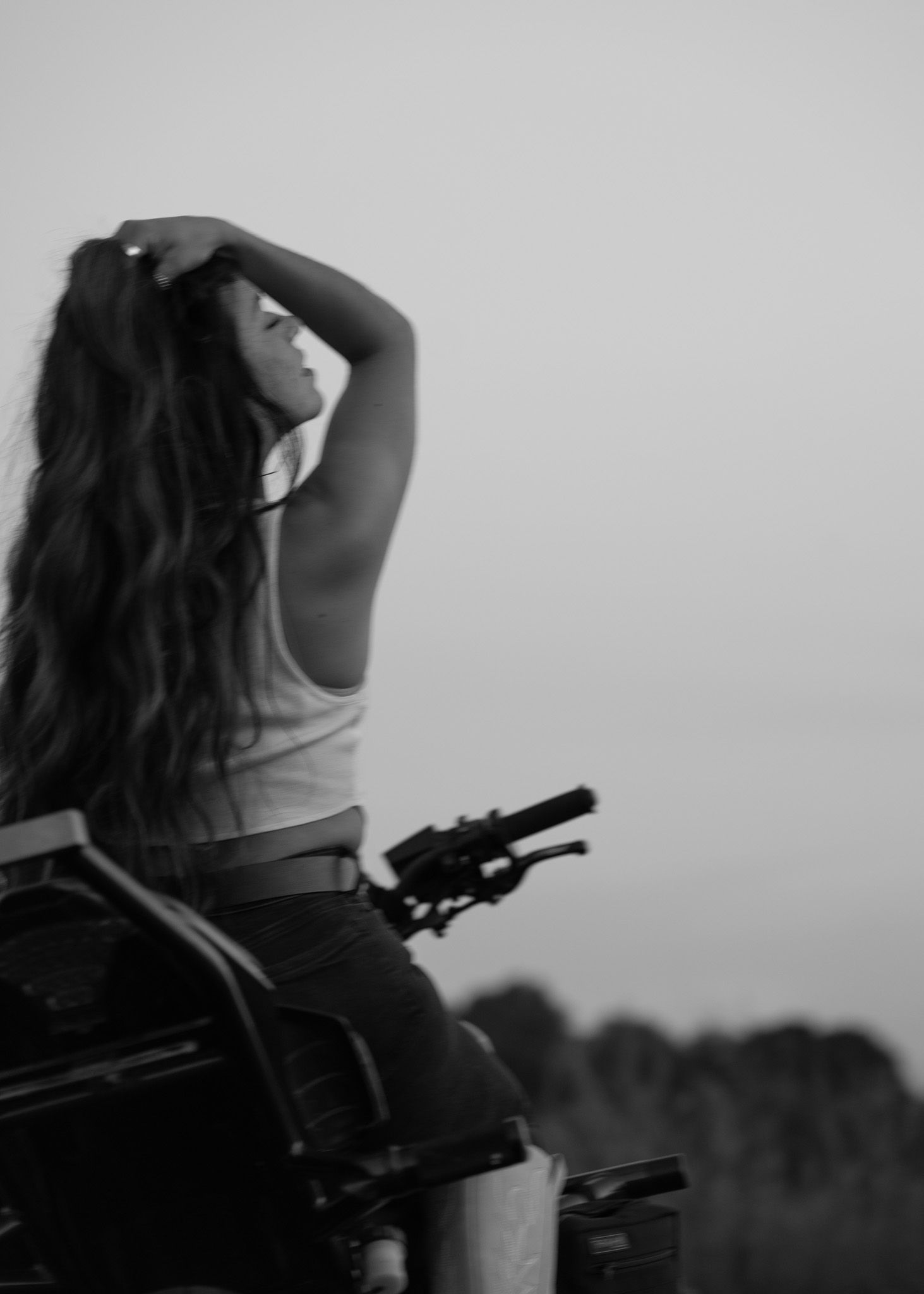 Silhouette of someone posing with camera equipment at dusk.