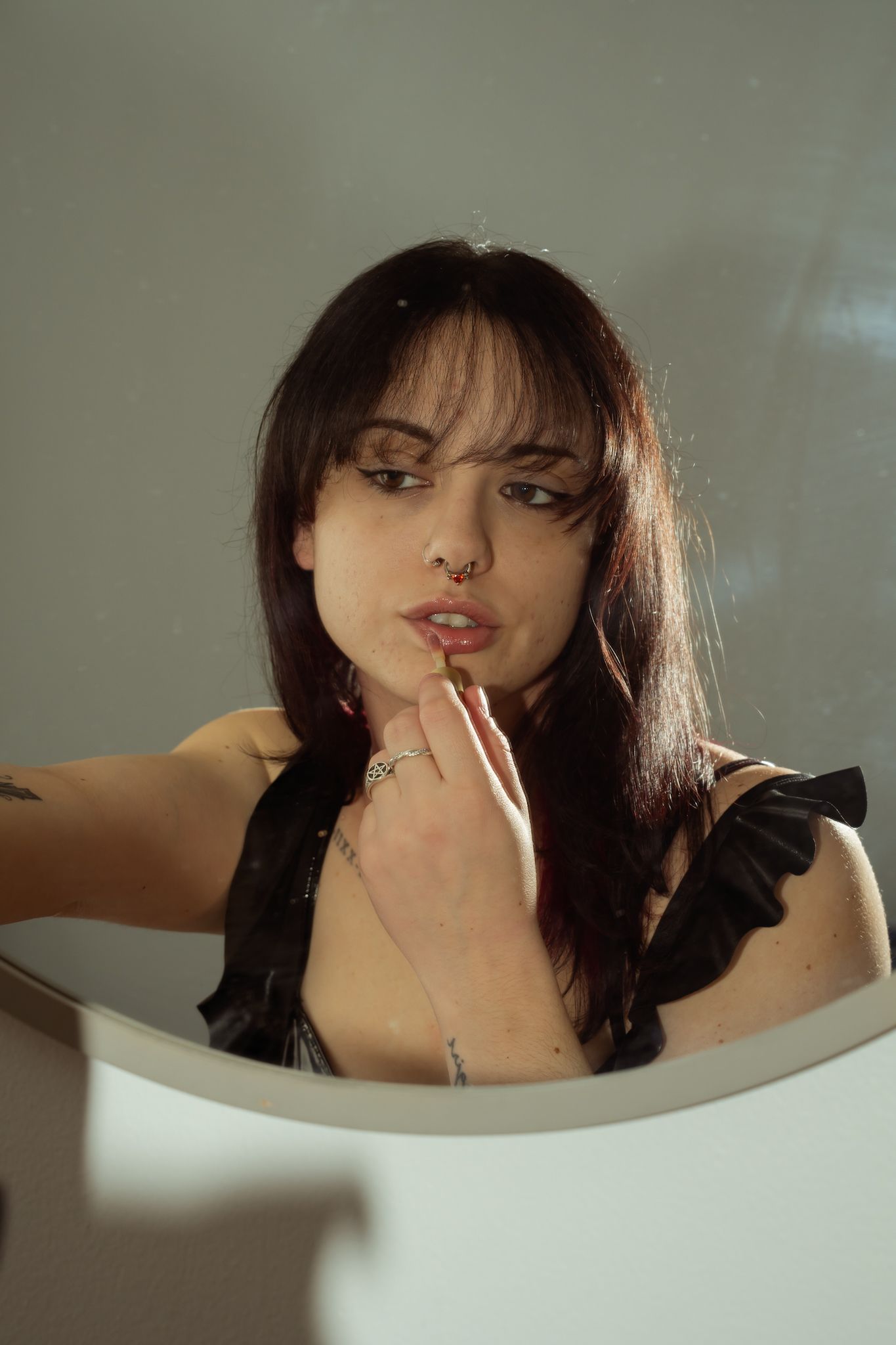 A series of artistic portraits showing someone in a bathtub with dark hair and dramatic lighting.