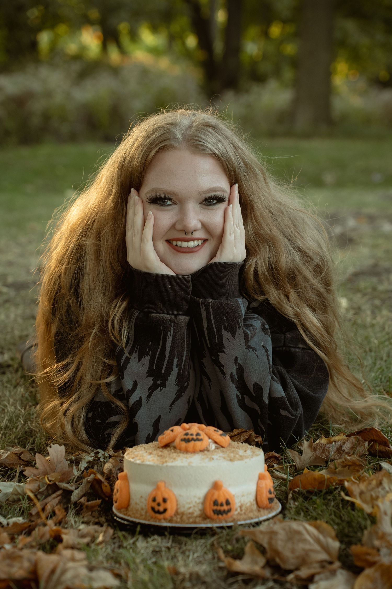 A fall portrait featuring a decorated Halloween cake with pumpkin designs.