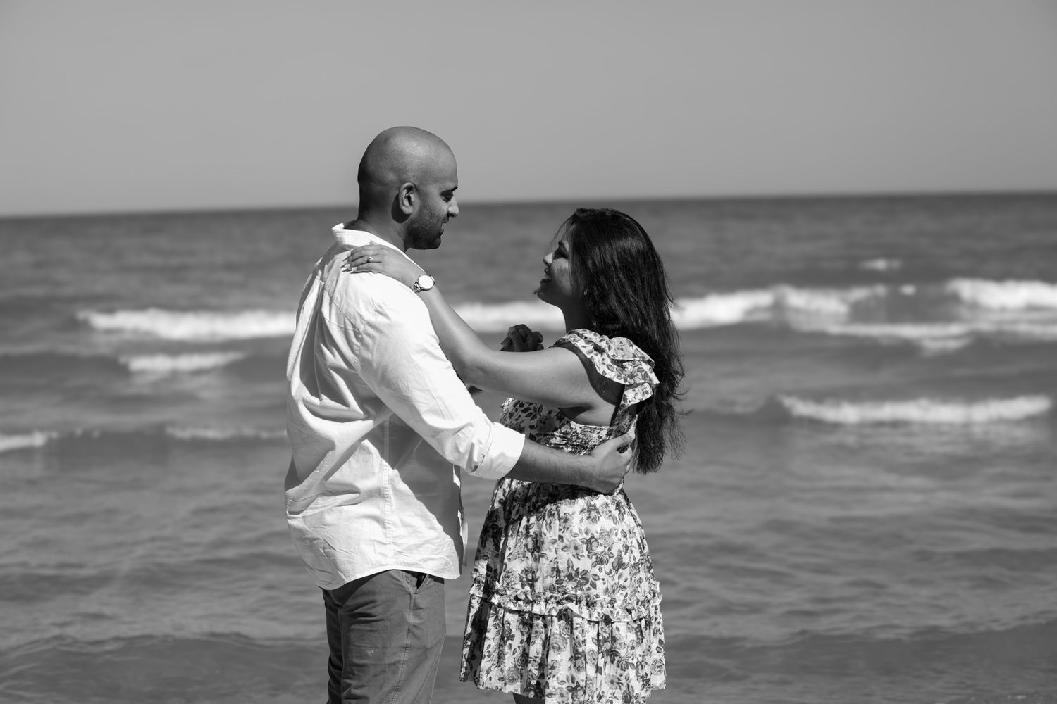 A couple shares romantic moments by the ocean during their photoshoot.