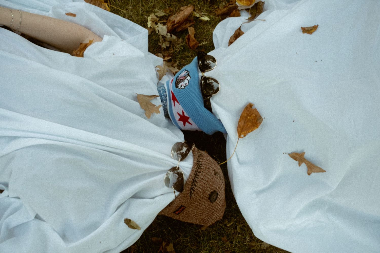 White ghost costumes with star decorations are arranged on the ground outdoors.