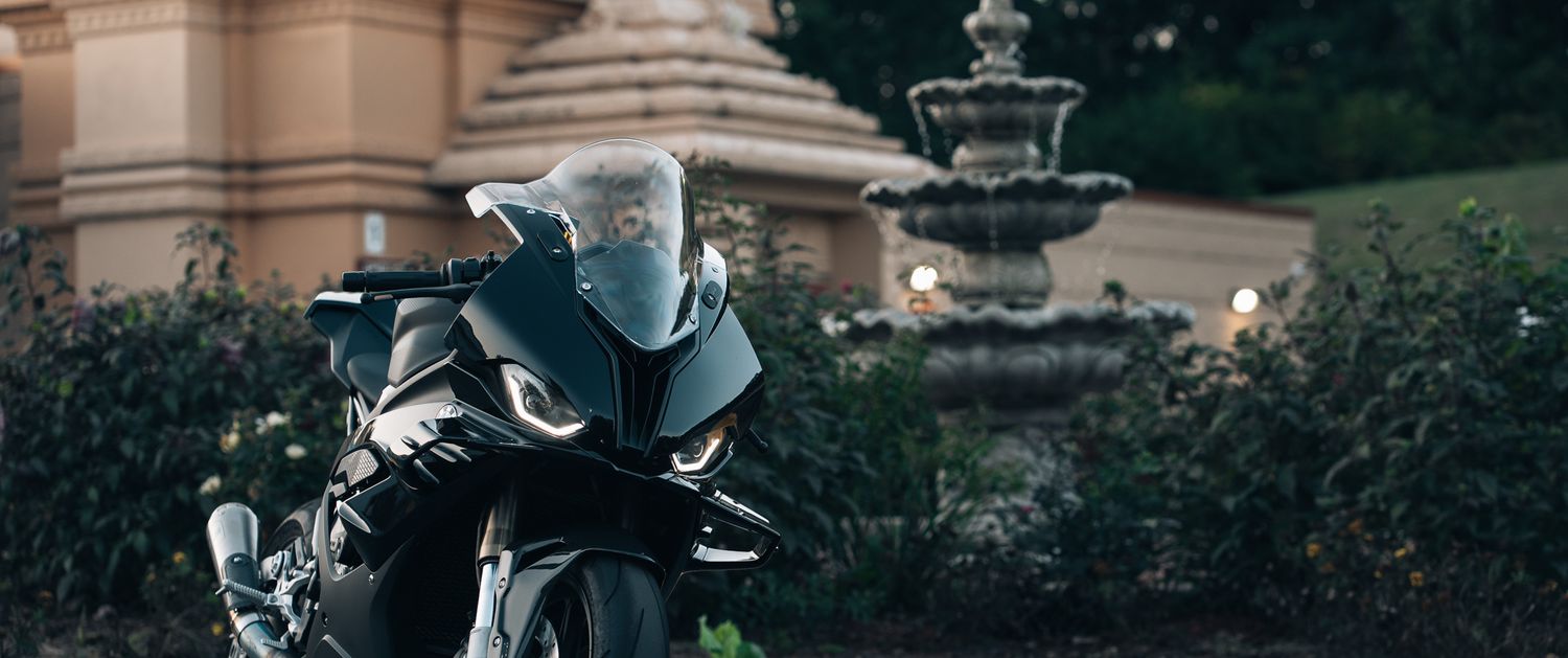 Black BMW motorcycle parked against a dark architectural backdrop.