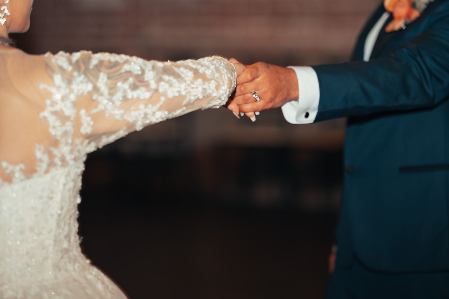 Close-up of hands during an intimate wedding dance moment.