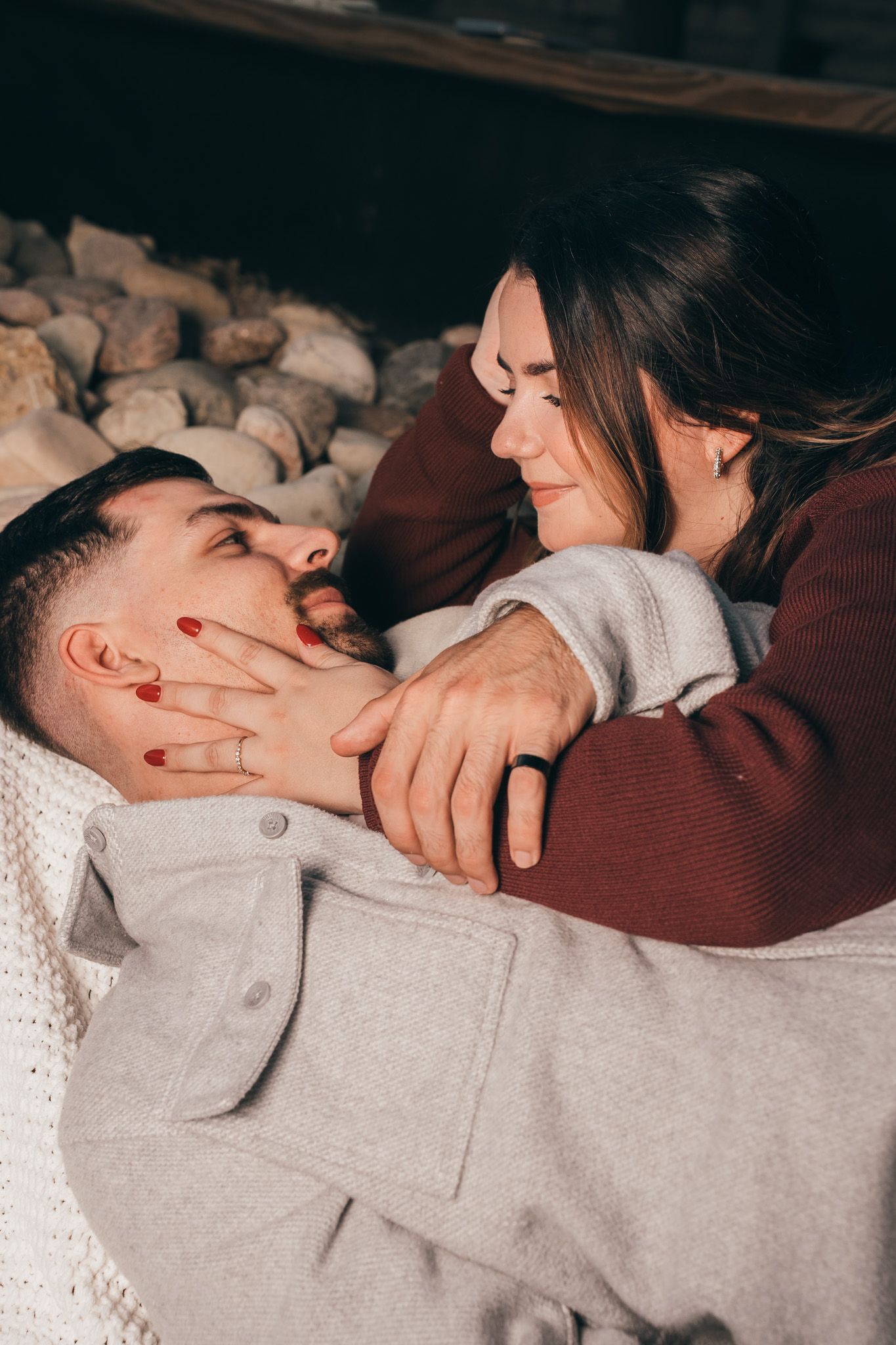 Intimate couple moments captured in warm tones on a cozy bed.