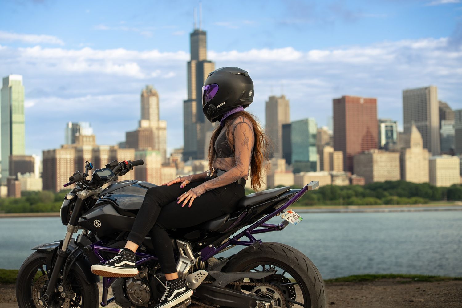 Sport bike rider overlooking Chicago's lakefront skyline on sunny day.
