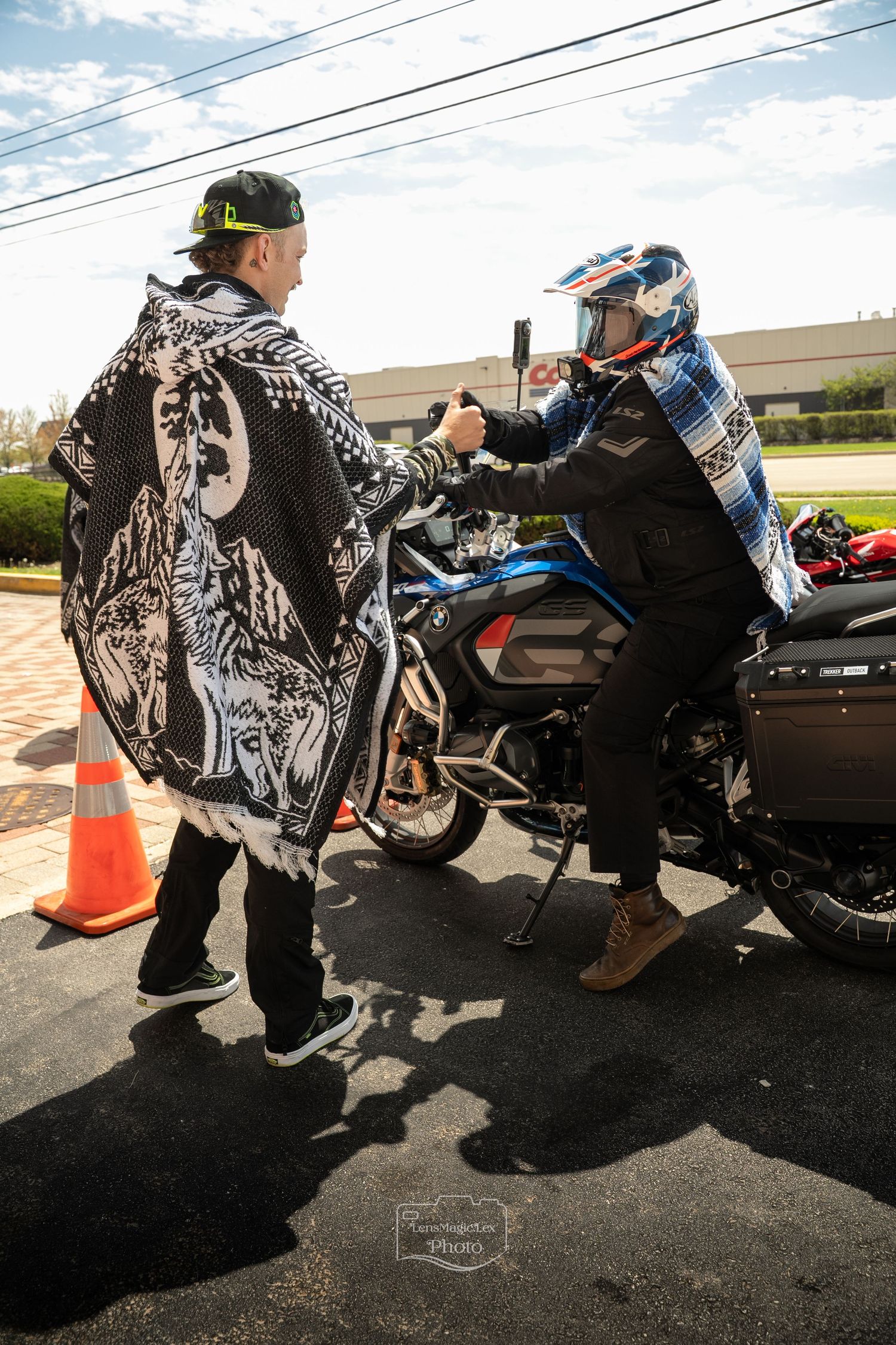 People sitting on motorcycles in a parking lot wearing patterned clothing.