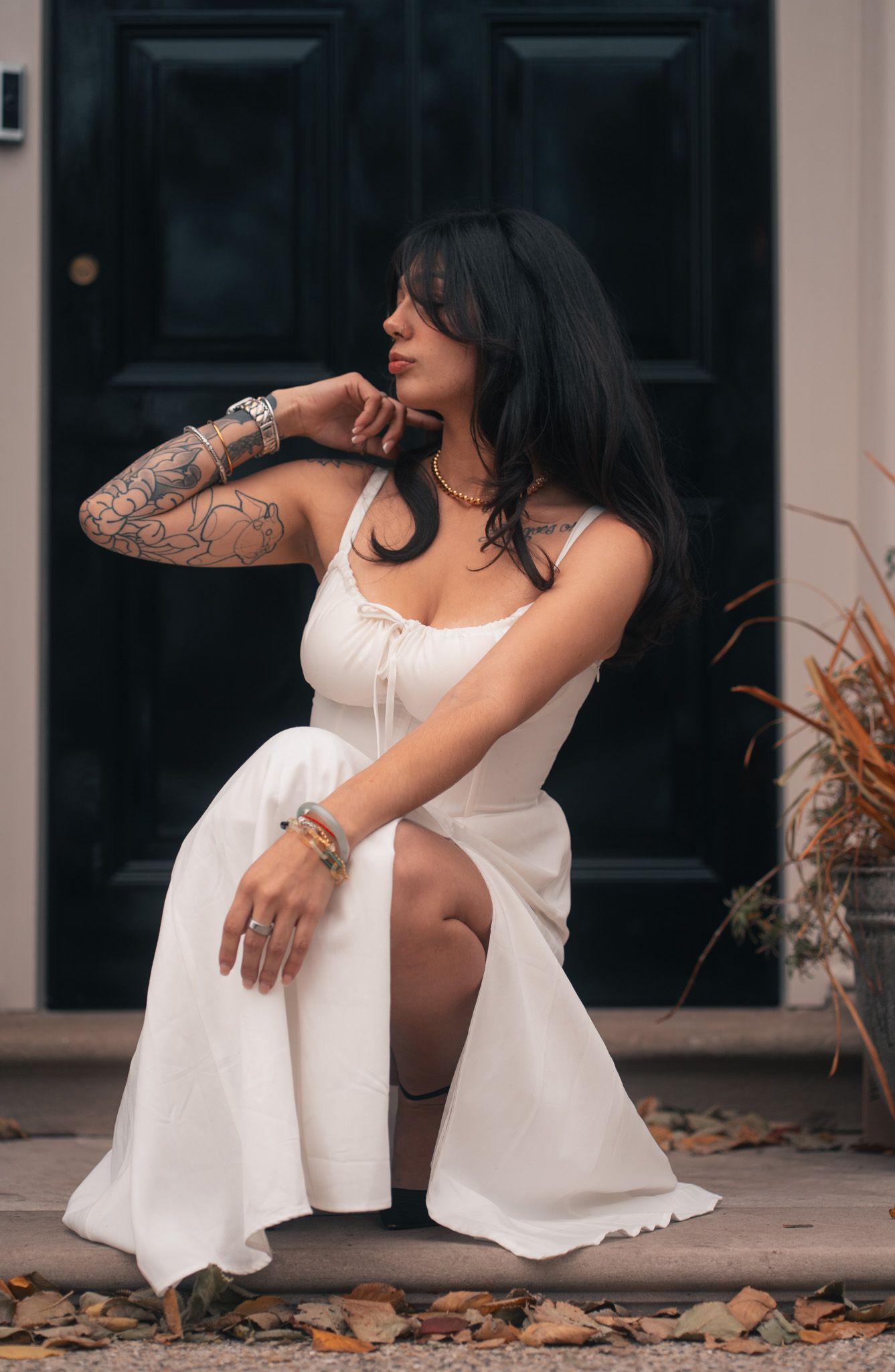 A person in a white dress sits on concrete steps in an artistic photo series showing different cropped poses.