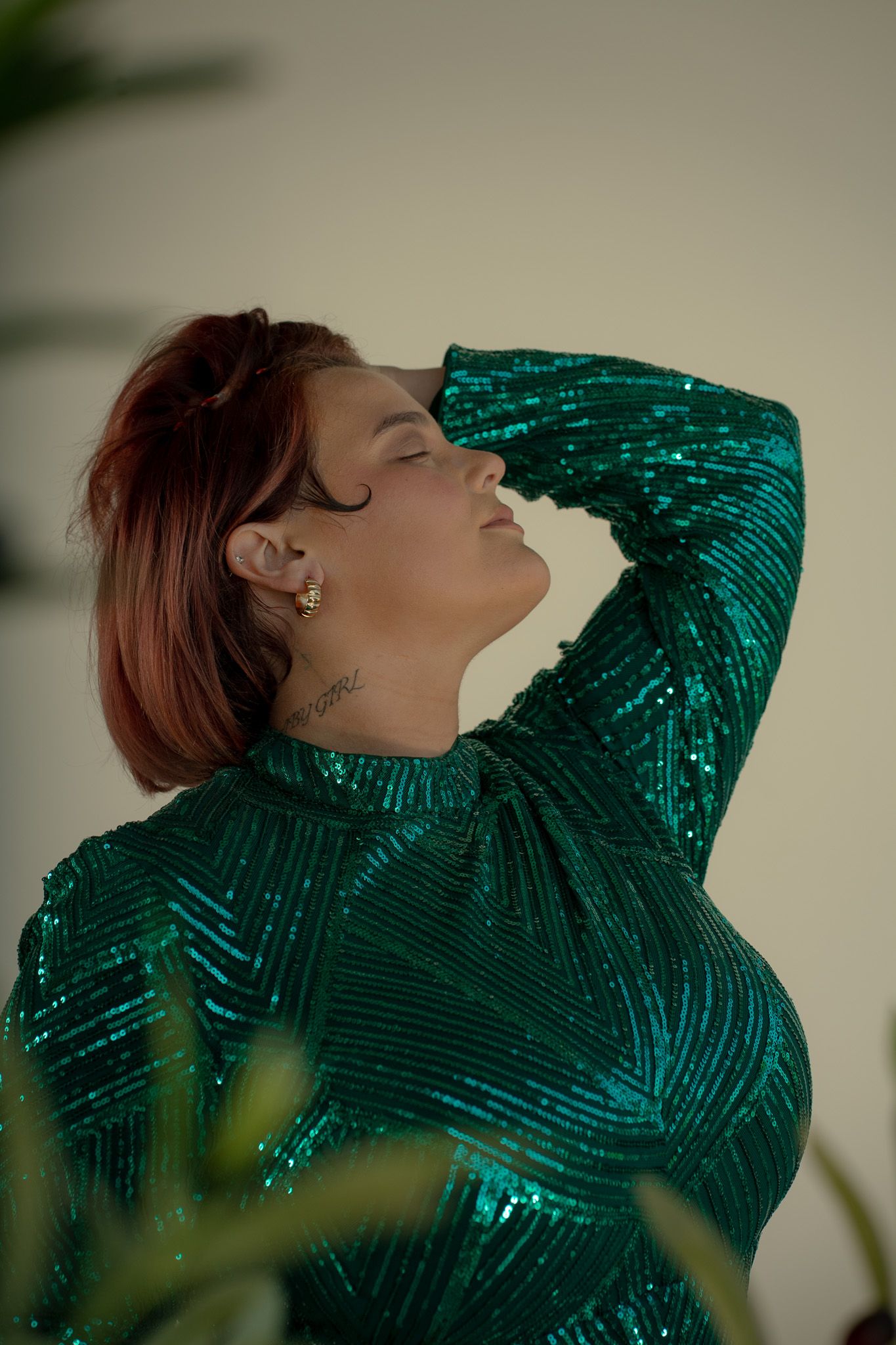 Glamorous pose in sparkling emerald green sequin dress.