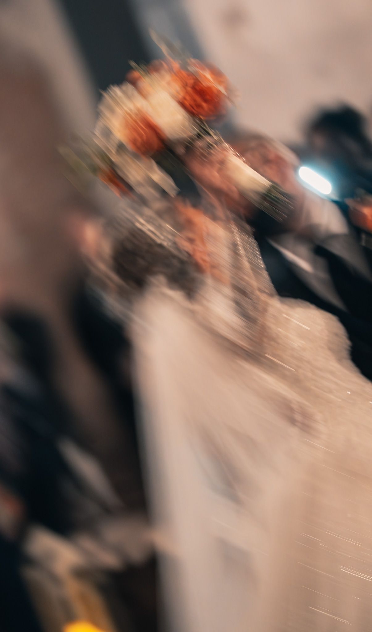 Motion-blurred image of a wedding reception dance floor with soft lighting and movement.