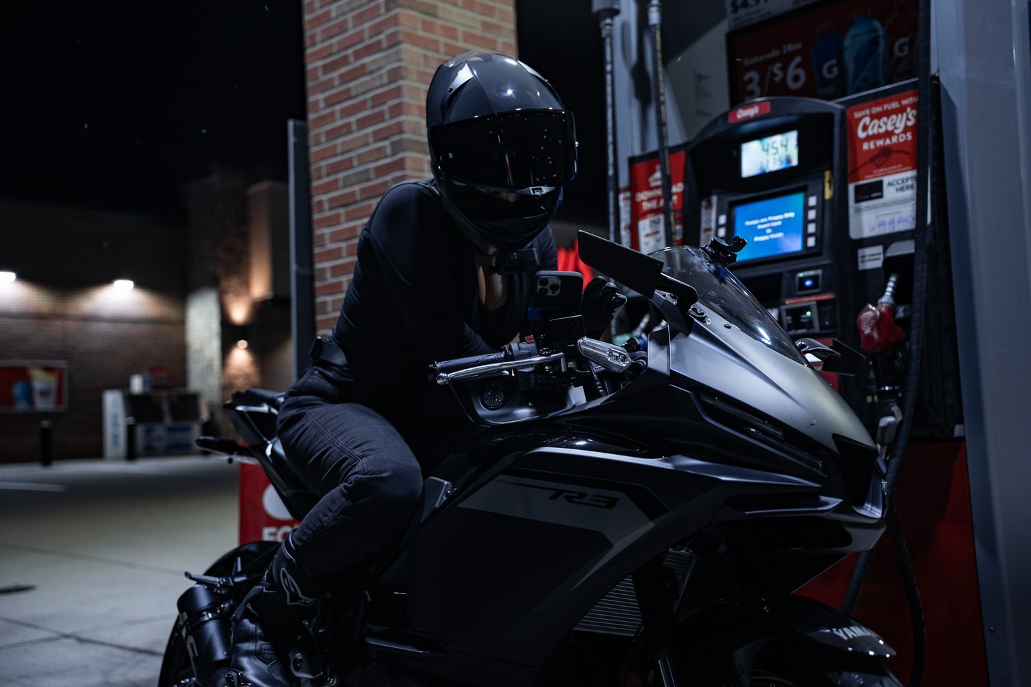 Dark motorcycle parked in dimly lit garage or service station.