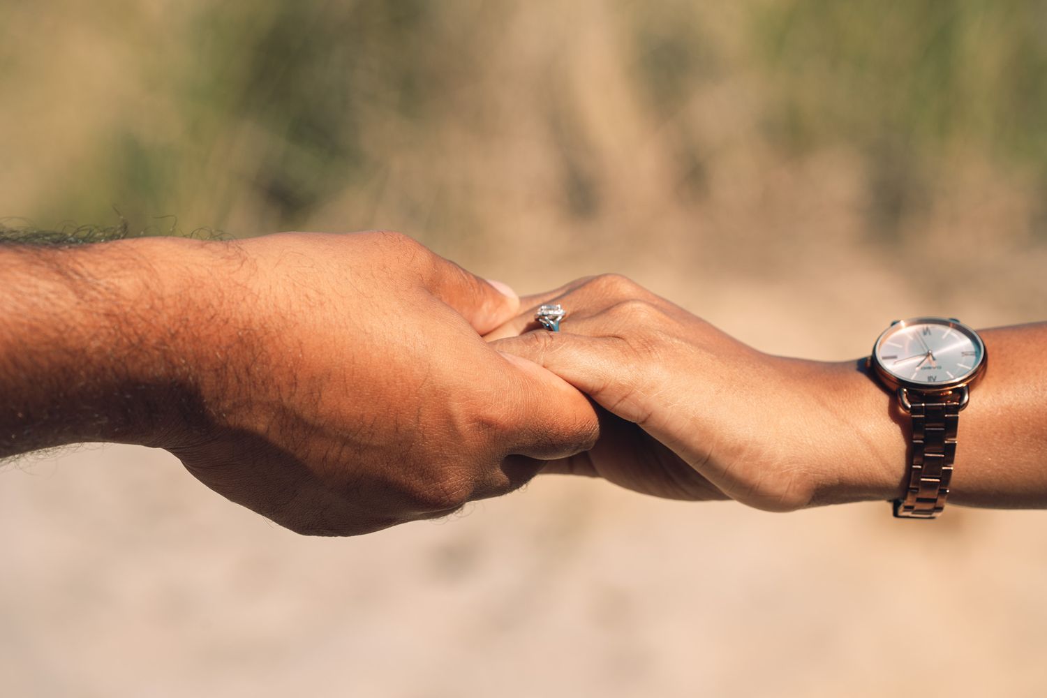 Close-up sequence of hands exchanging rings on blurred background.