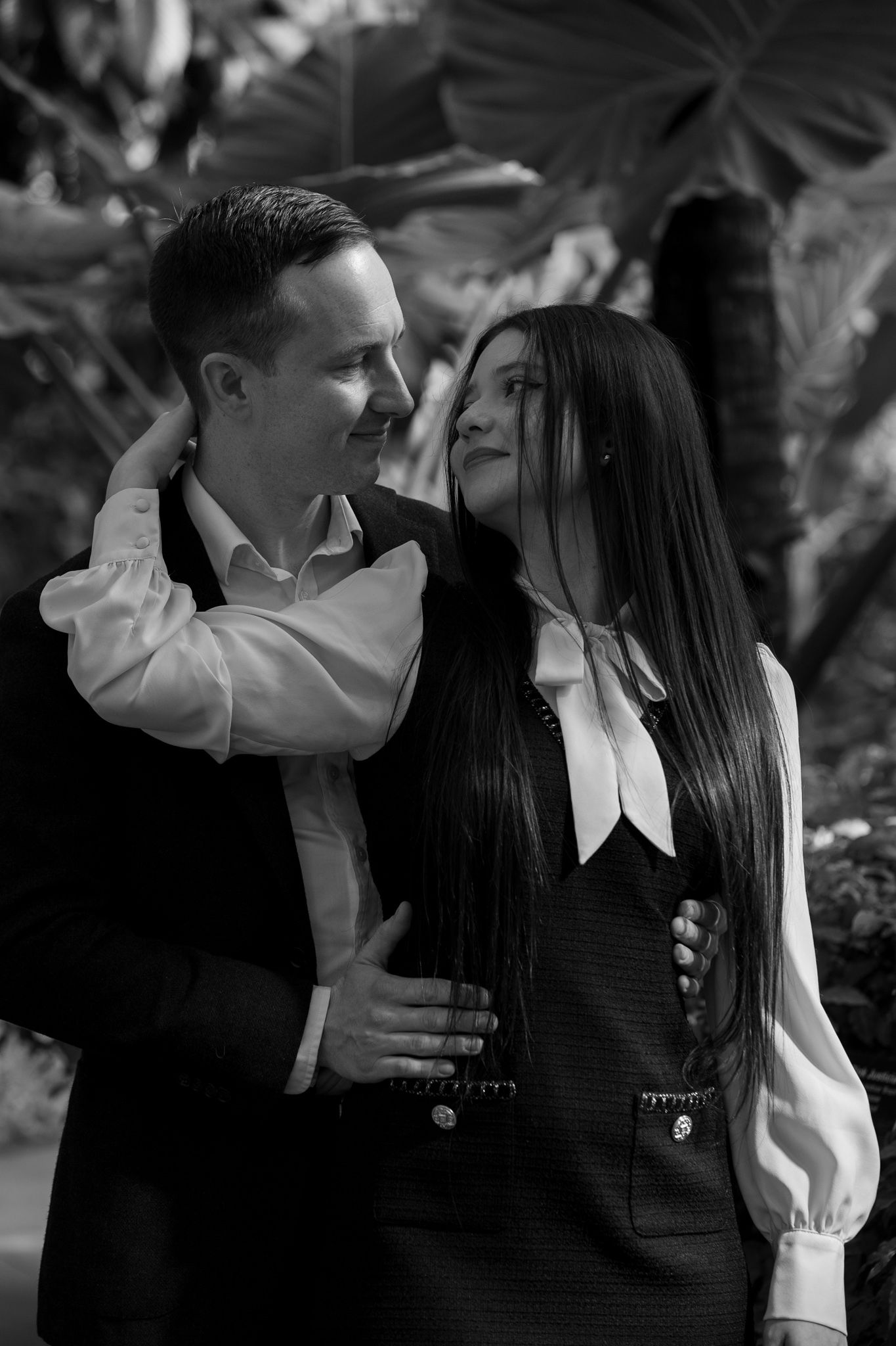 Black and white romantic photo series showing a couple embracing and sharing tender moments in an outdoor setting.
