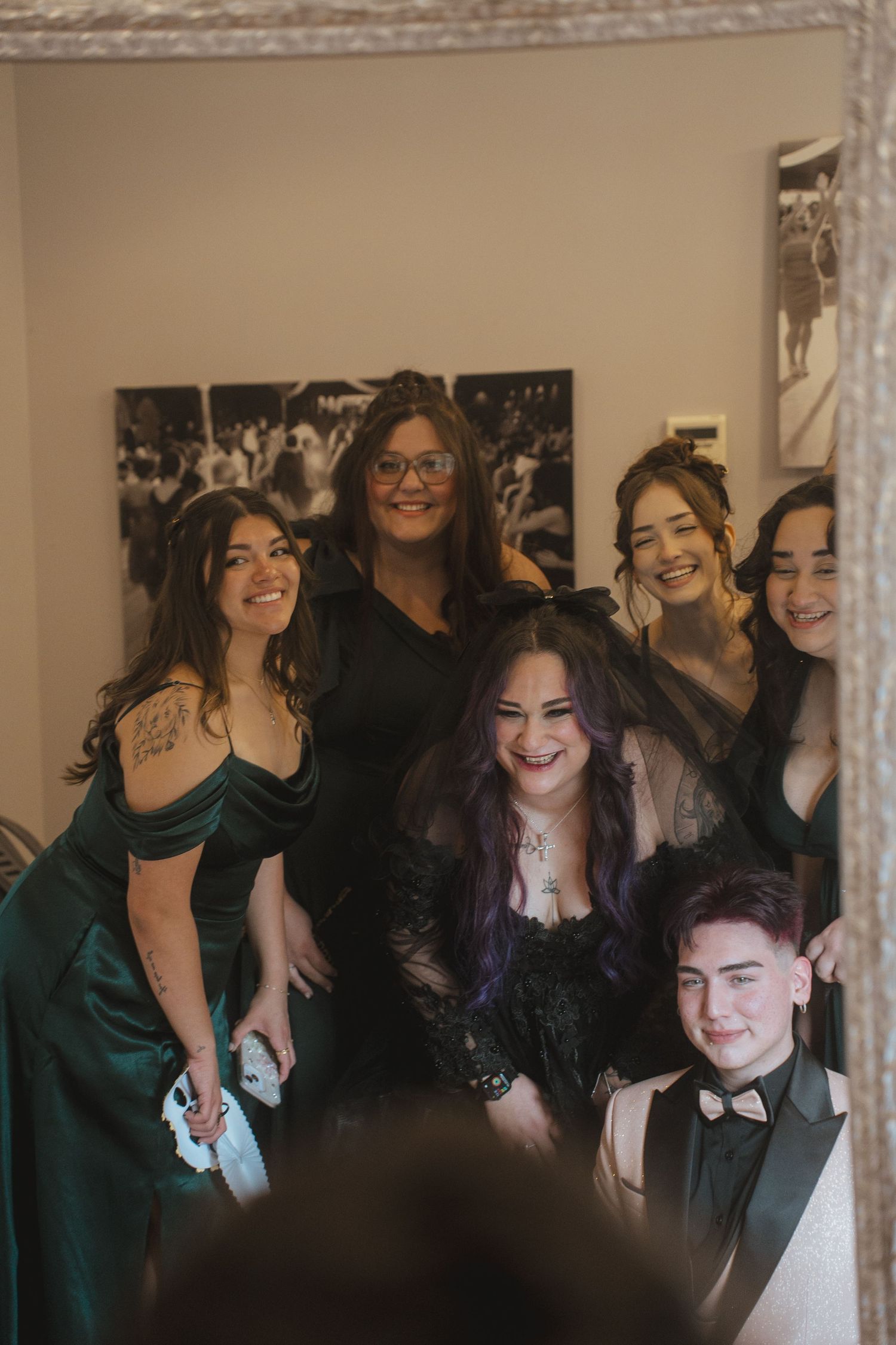 Celebratory group photo session with people in formal attire at indoor event.